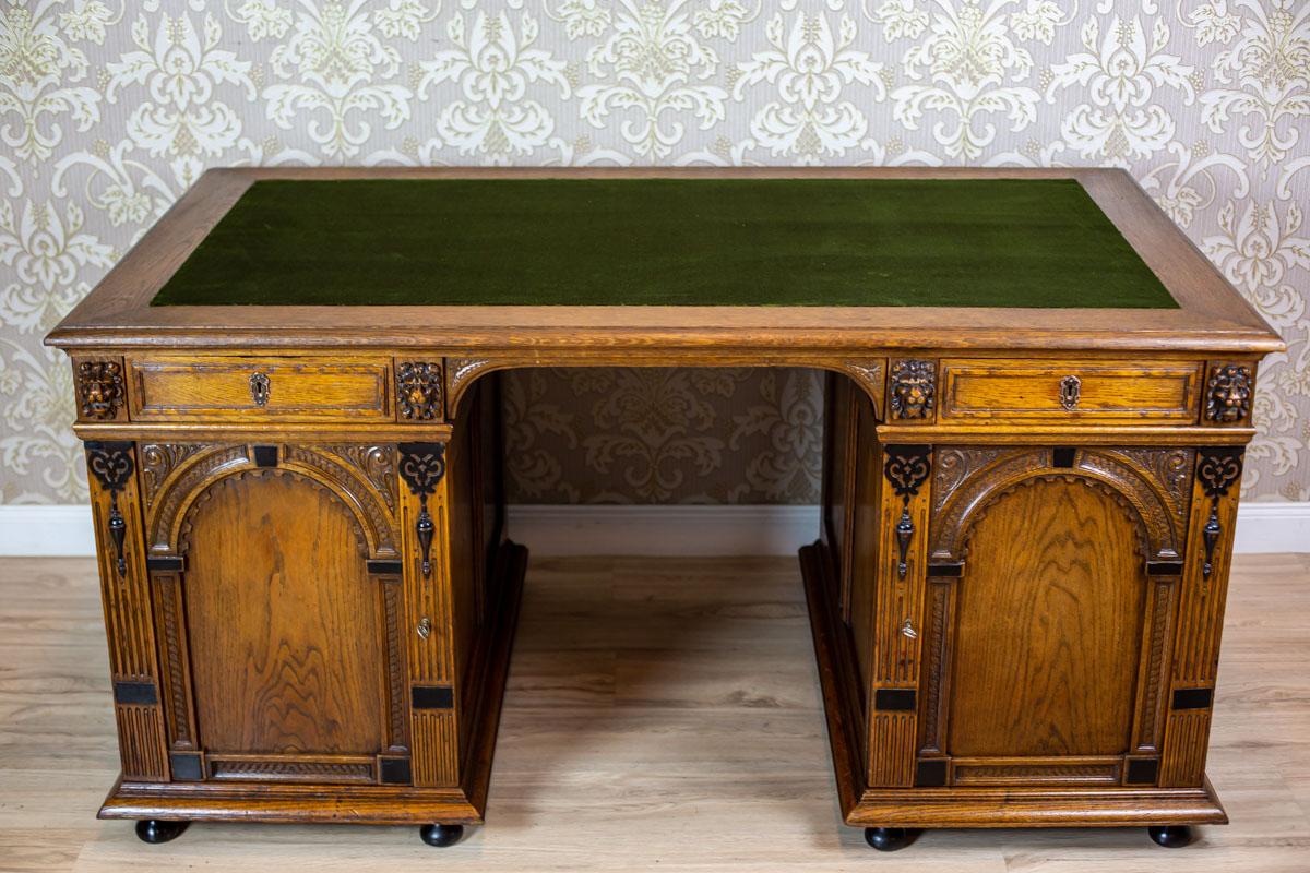 We present you a big man’s desk, made of oak wood.
It was manufactured in Q4 of the 19th century.
This piece of furniture is composed of two separable cabinets, closed with a door, and a top with drawers incorporated into it.
The door panels are