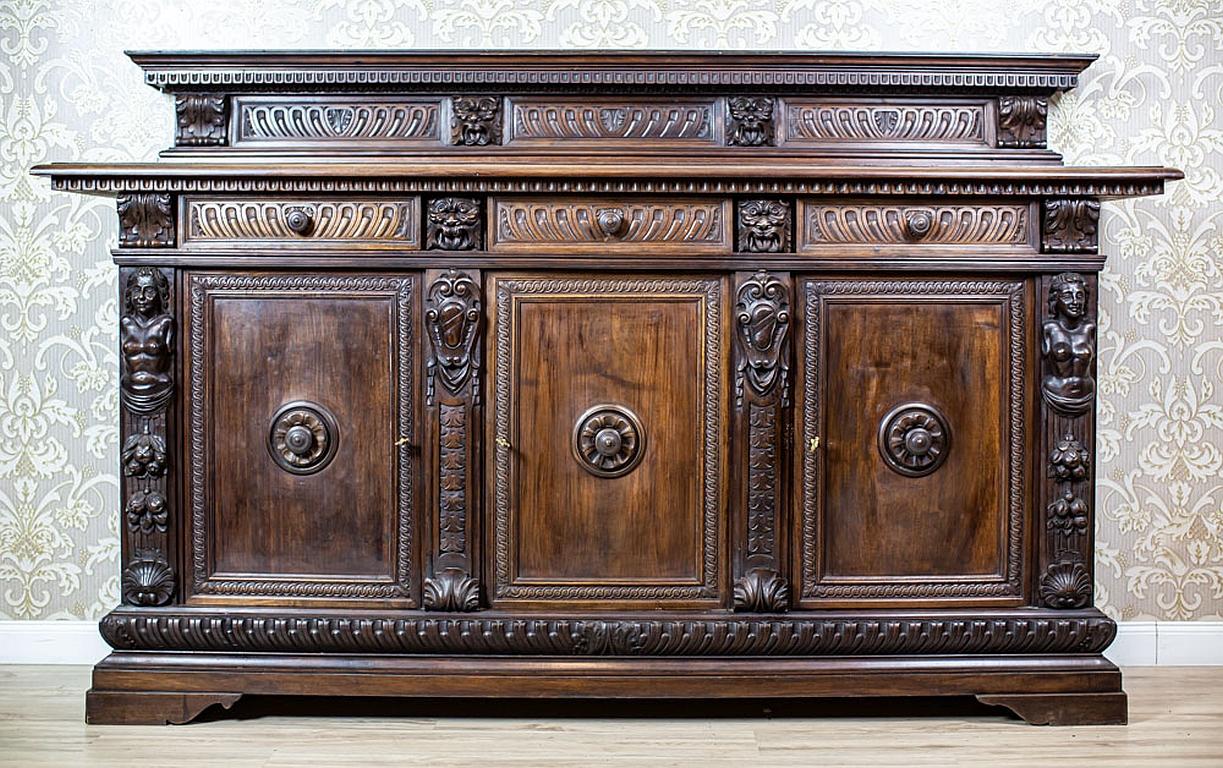 19th-Century Neo-Renaissance Oak Sideboard with Carved Decorative Elements

We present you a massive Neo-Renaissance oak sideboard from Q4 of the 19th century.
The three-door base hides three drawers on the axis and its structure is divided.
The