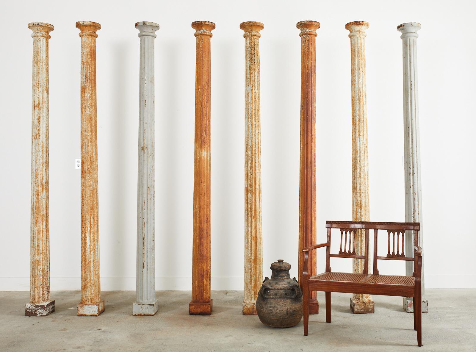 Amazing set of eight matching 19th century neoclassical, or Greco Roman style cast iron columns featuring an elegant fluted shaft. The columns are complete one piece casts with a square base measuring 7.5 inches wide. The capitols feature a double