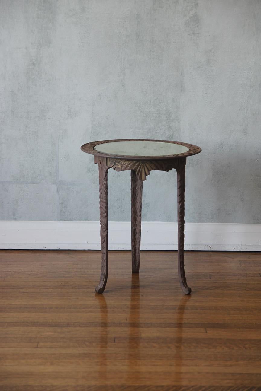 Remontez le temps et rehaussez votre espace avec cette étonnante table de pub néoclassique en fonte à base figurative datant du début des années 1900. Elegamment surmonté d'un miroir rond, ce trésor anglais n'est pas seulement une table, c'est une