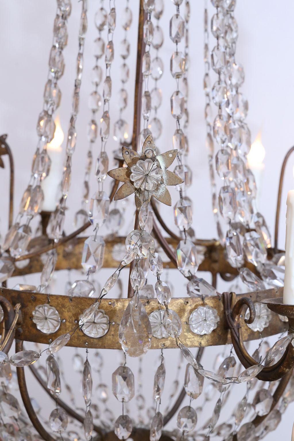 19th century neoclassical gilt-iron chandelier with six arms and crystal prism and pressed glass decoration. Newly wired for use within the USA with UL listed parts.
 