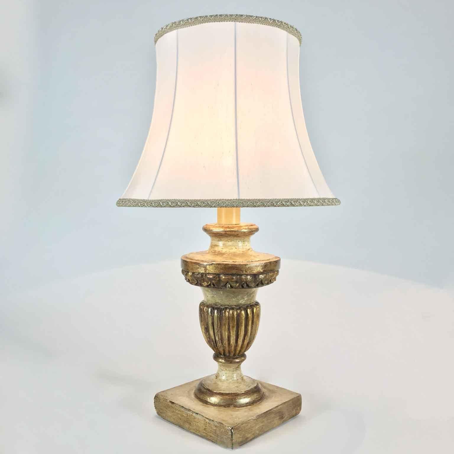 Early 19th century Italian neoclassical circular table lamp on square base, with frontal carving and decoration, ivory color painted and partially gilt with a mecca silver-leaf finish.
This antique table lamp is in good condition, comes from a