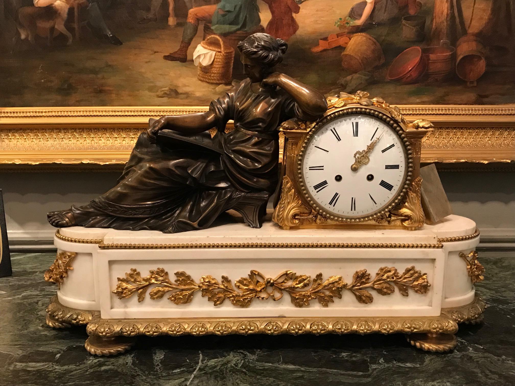 A fine 19th century neoclassical statuary white marble and gilt bronze figural mantle clock, the finely cast patinated classical female in seated pose juxtaposed to gilded bronze clock of circular form with beading, garlands of foliate and acanthus