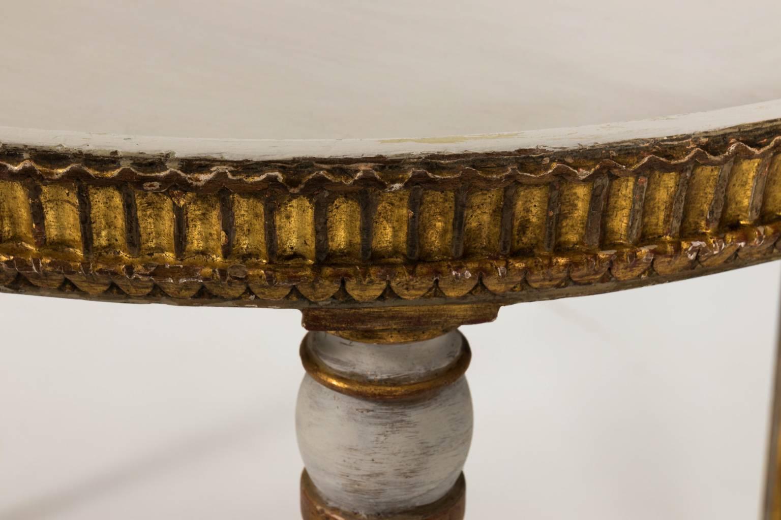 Early 19th century oval table in light grey paint and gold gilt with fluted ball-and-ring turned legs.