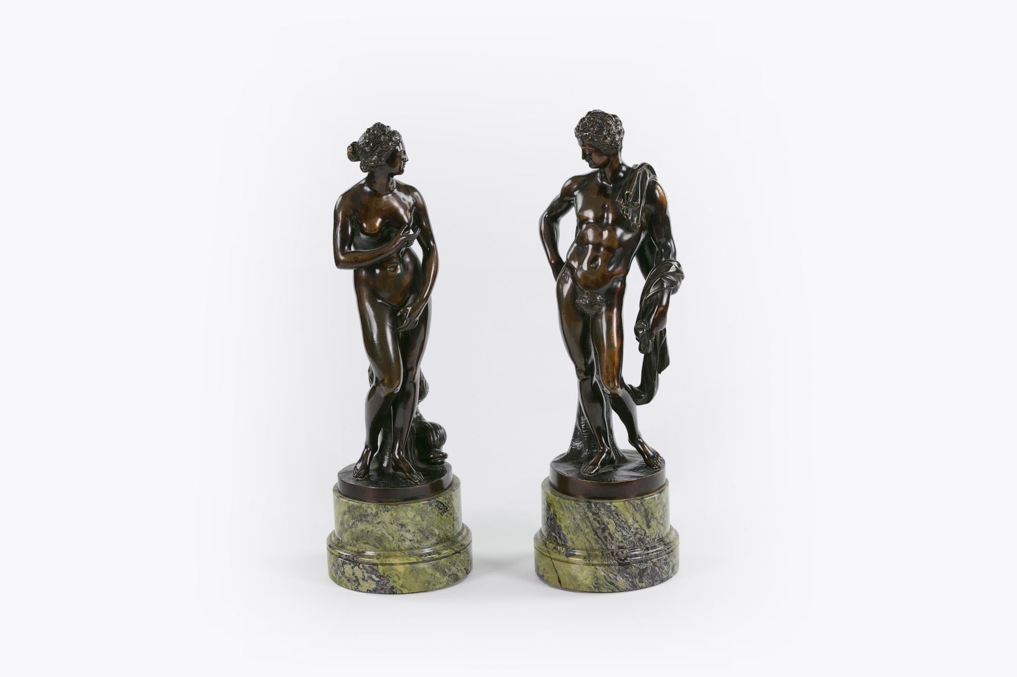 19th century neoclassical pair of patinated figural bronzes depicting Capitoline Venus and Apollo raised over light green Greek antique marble socle of circular form.
