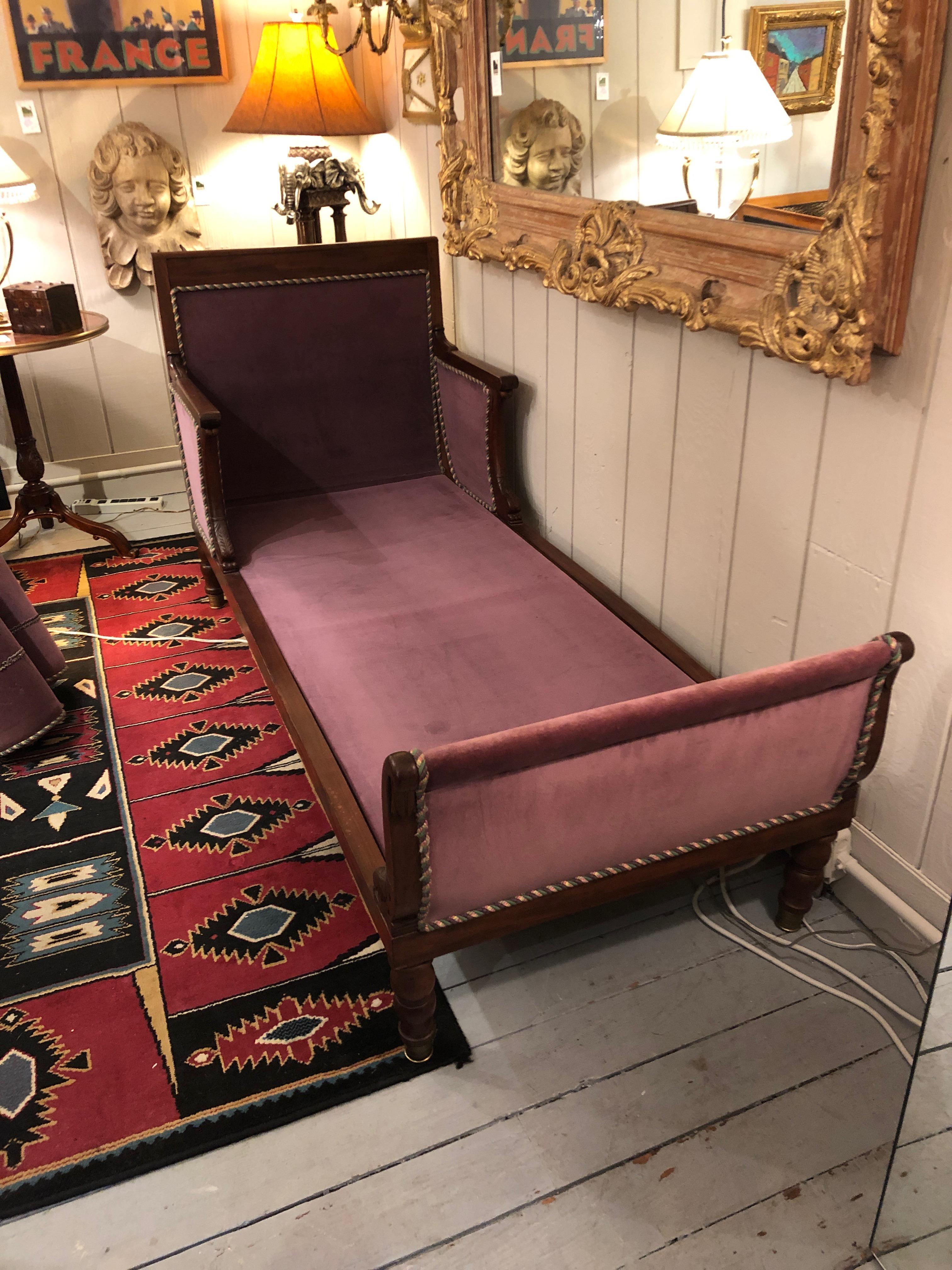 Romantic Parisian 19th century mahogany neoclassical daybed having dolphin decoration, turned feet, extension shelf on one end and aubergine velvet upholstery with silk rope detailing.
Measures: Bed cushion is 72 inches or 6 ft long x 30 D
Arm