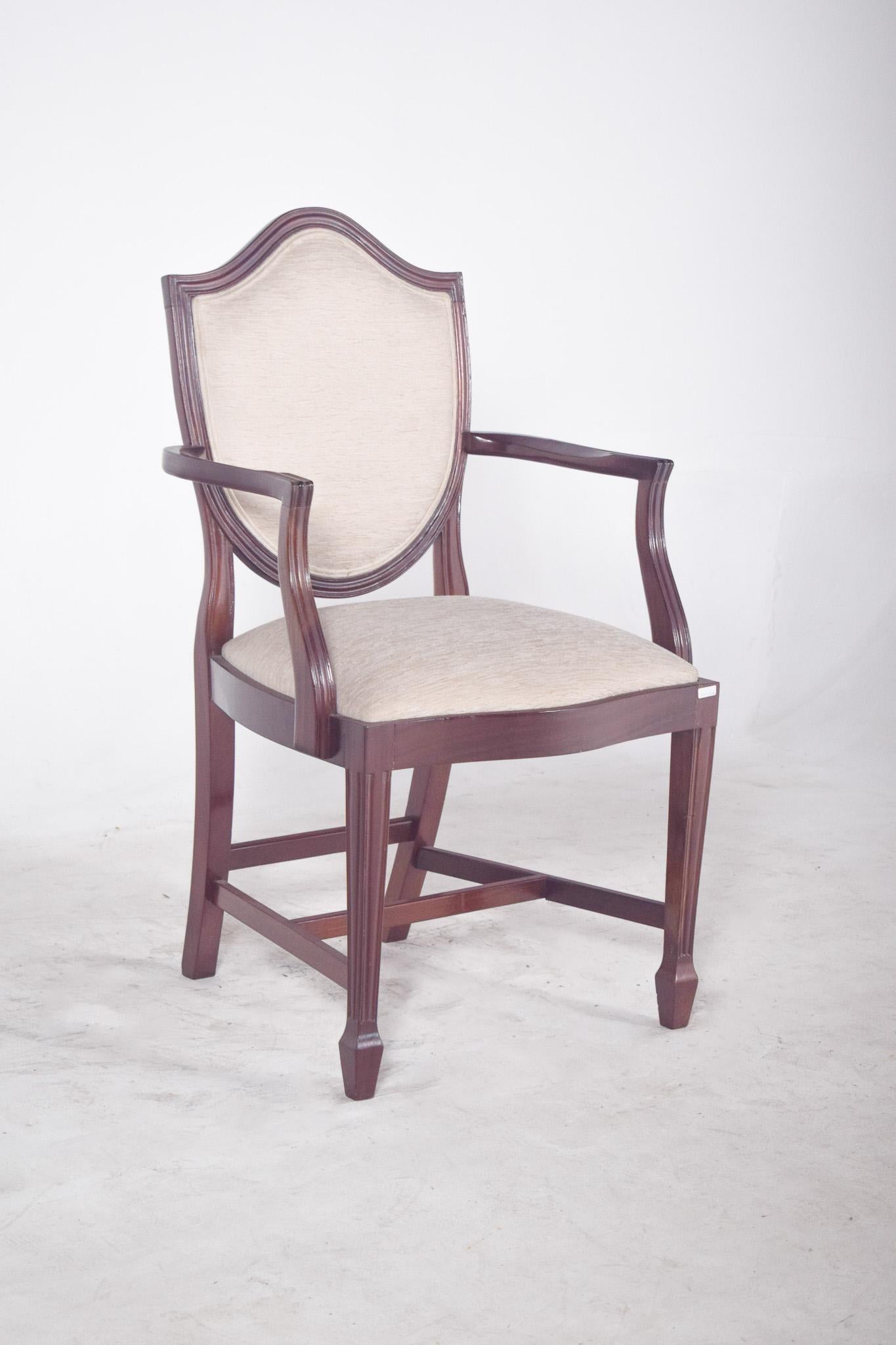 Fauteuil Hepplewhite. Ces chaises séduisent par leur design élégant et délicat. Le point fort est le dossier en forme de bouclier aux contours doux et incurvés, typique du style Hepplewhite, très répandu à la fin du XVIIIe siècle et au début du XIXe