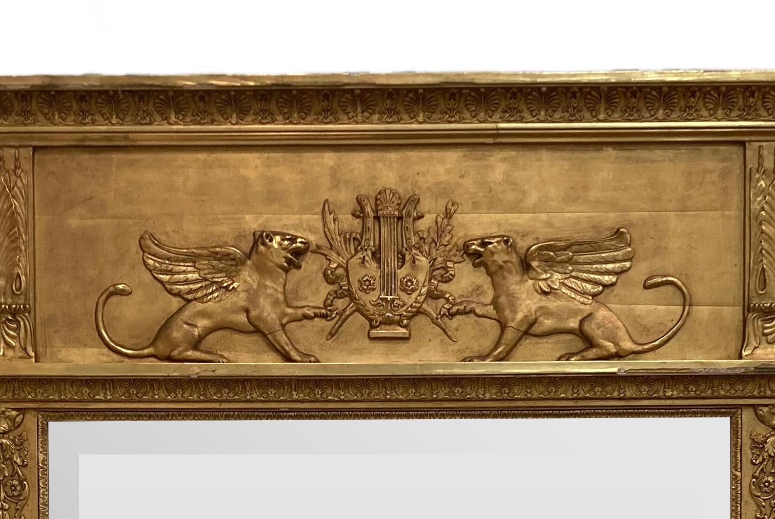 Specchio in stile neoclassico francese del XIX secolo con cornice in legno dorato con due grifoni affiancati da uno stemma.