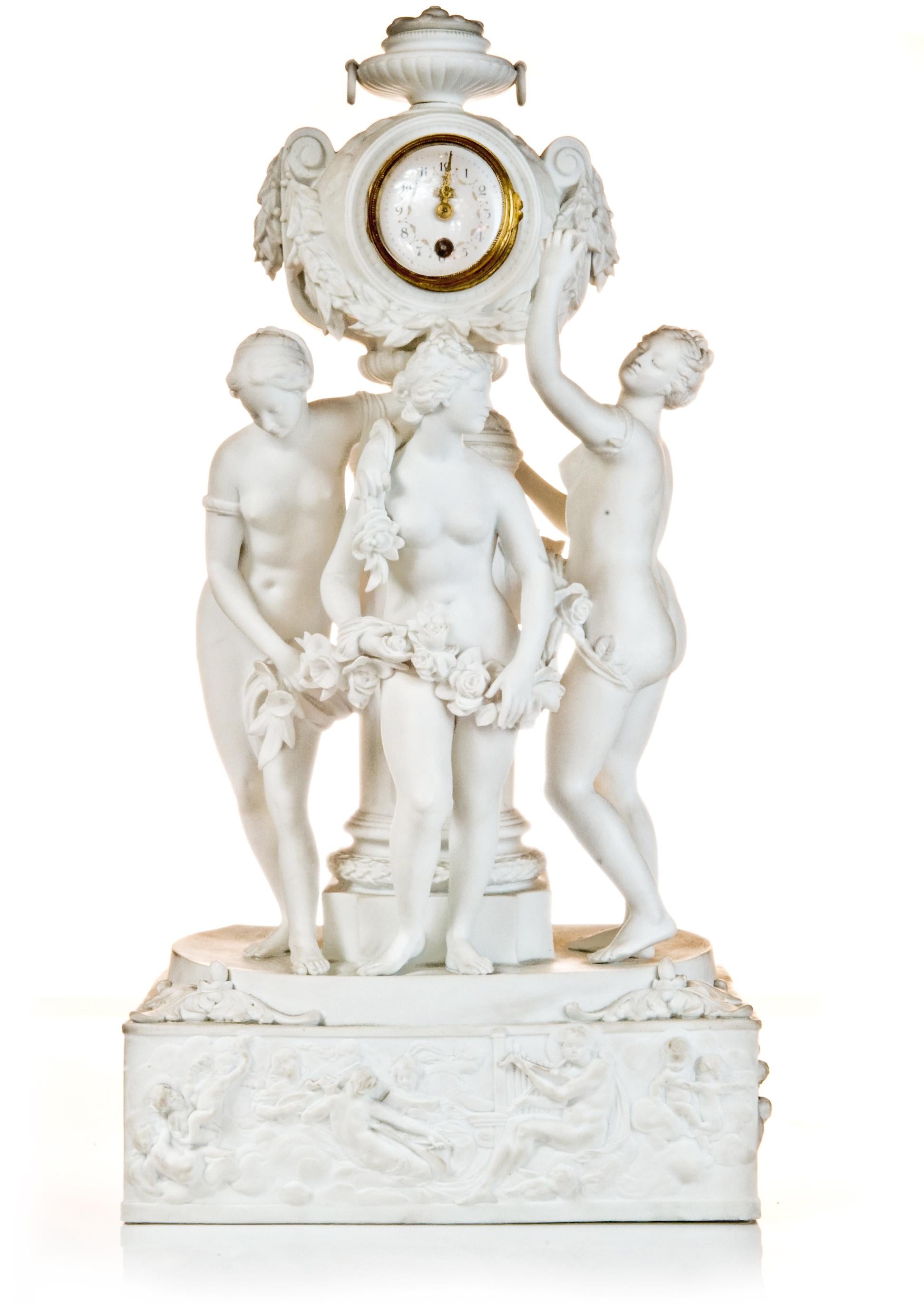Une exquise et monumentale horloge de cheminée en porcelaine allemande du XIXe siècle représentant les Trois Grâces. Cette impressionnante horloge de cheminée de la fin du XIXe siècle est magnifiquement réalisée en porcelaine bisque blanche mate et