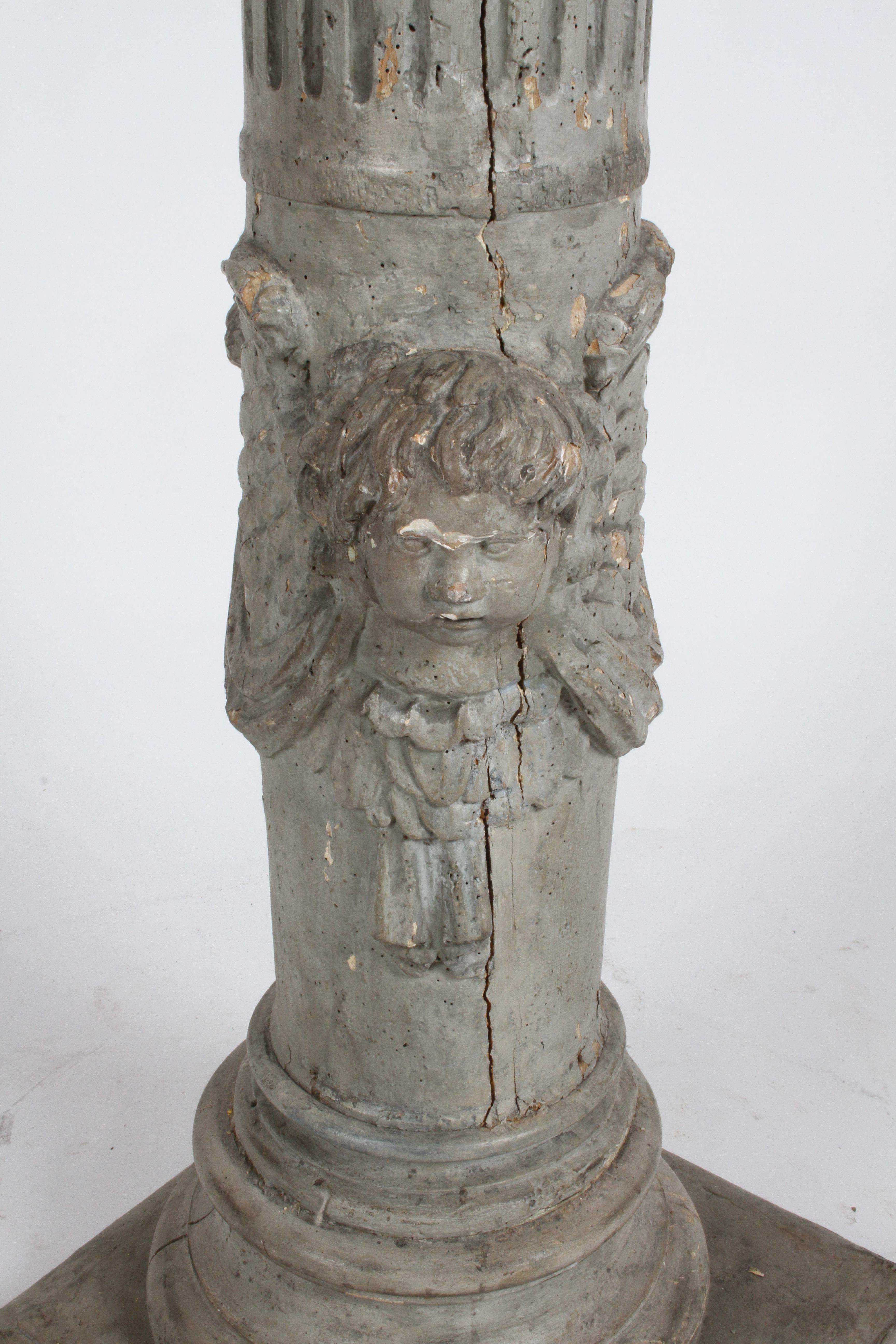 From a very prominent St.Louis estate this 19th century neoclassic style fluted wood decorative column with carved angel with wings, swag and drape, painted in a pewter gray paint. Loss of paint, old age cracks, insect bores, column on newer square