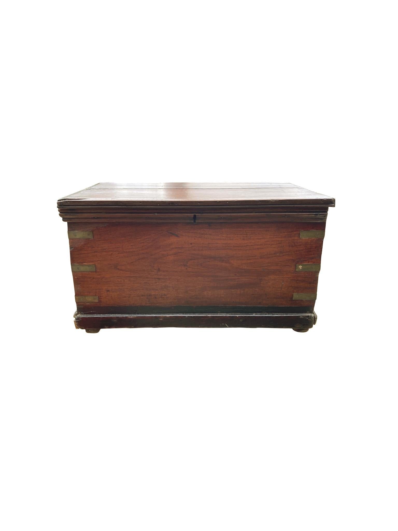 New England sea chest, handcrafted in the 19th century from walnut with brass binding and rope handles. Among its many charms, we love the rich red-brown tone of the wood and the colorful hand-painted star design on the interior of the