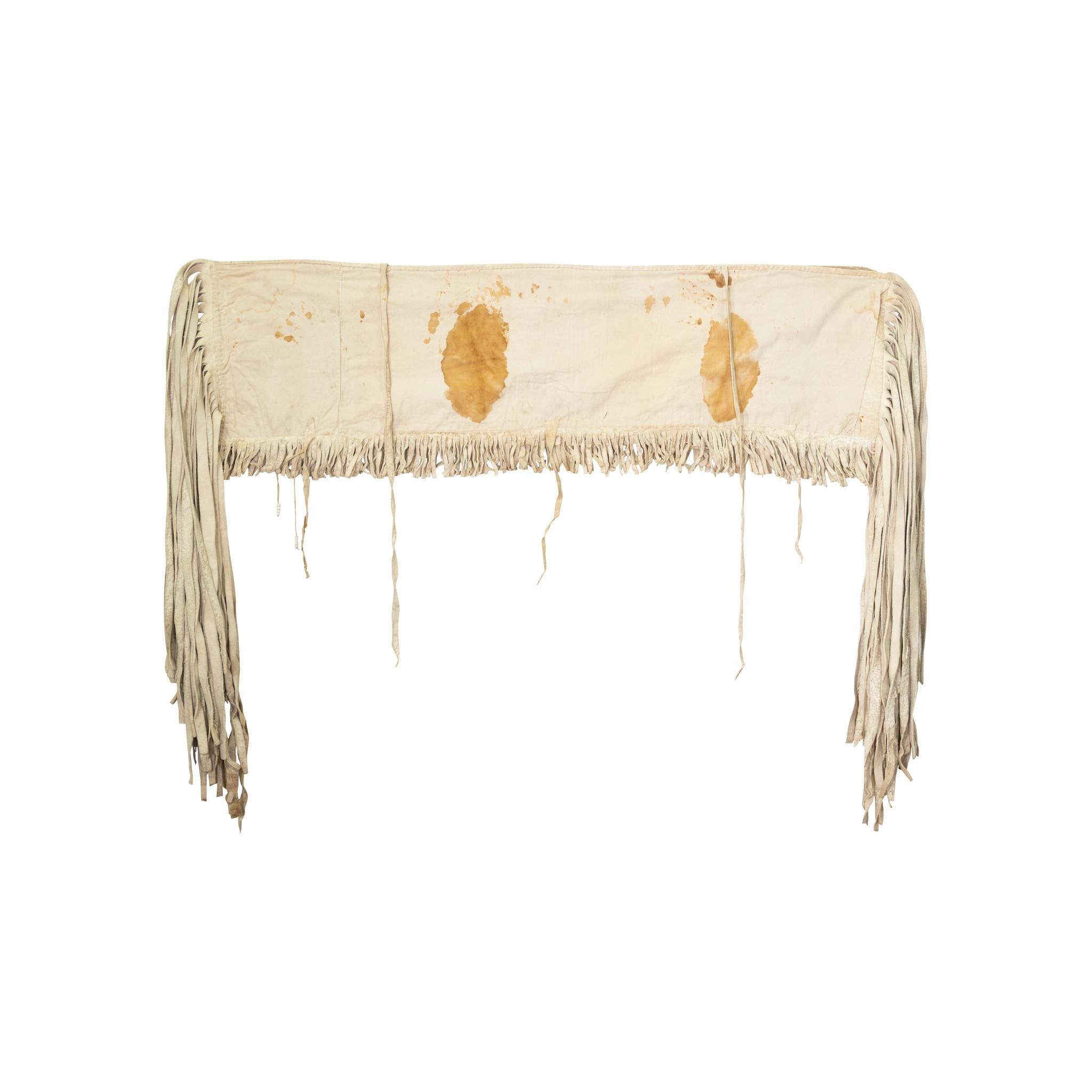 Abaissement de la selle des Nez Perce. Panneaux de perles florales tannées sur fond jaune. Peau de wapiti tannée à la cervelle avec longue frange. Sac à farine doublé de taches dues à son utilisation. Longue frange aux deux extrémités. En provenance