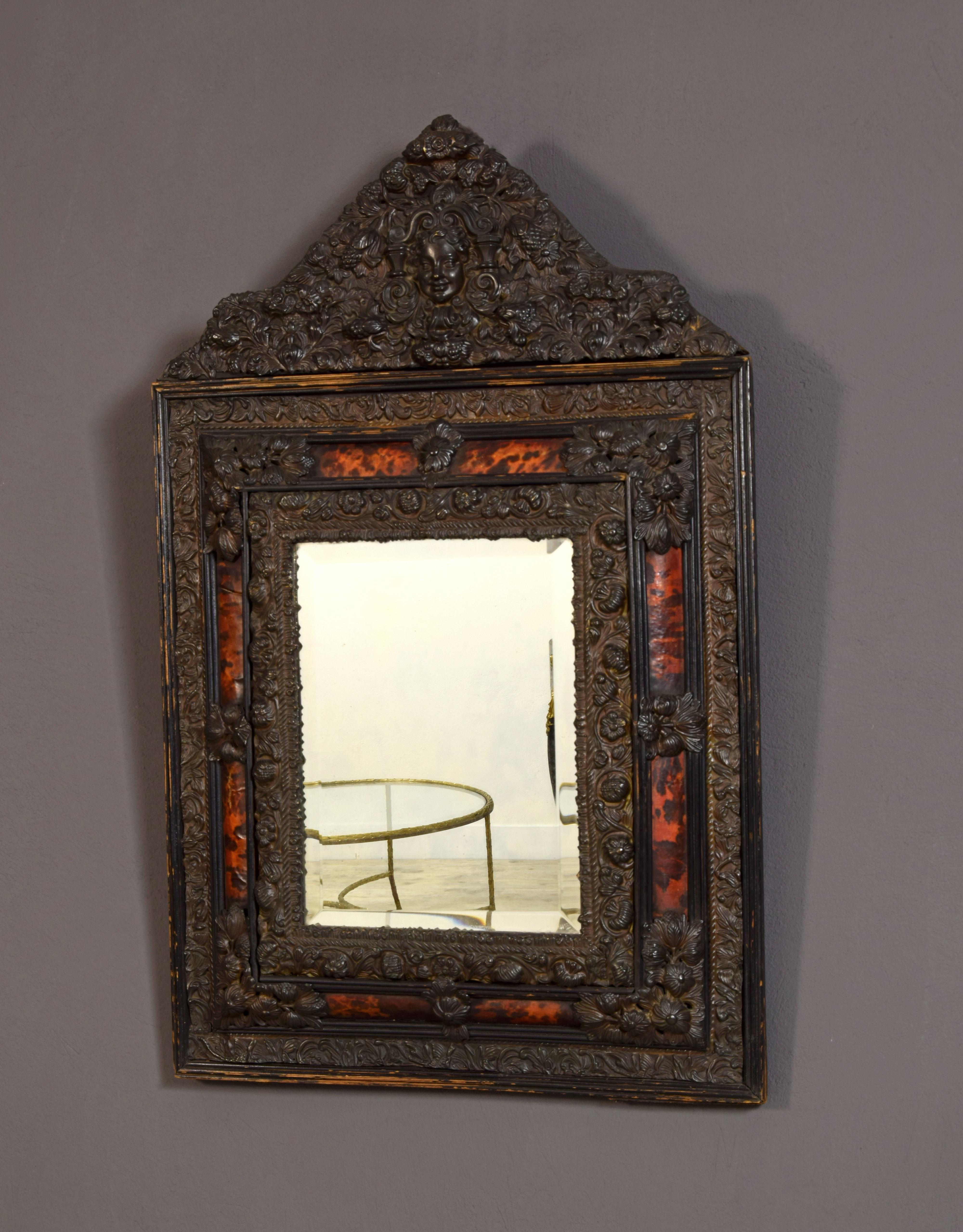 19th century, Northern Europe embossed and burnished metal mirror

Small and refined mirror of the 19th century in Regency style, made in the north of Europe, in embossed and burnished brass. This particular mirror has an ebonized external frame