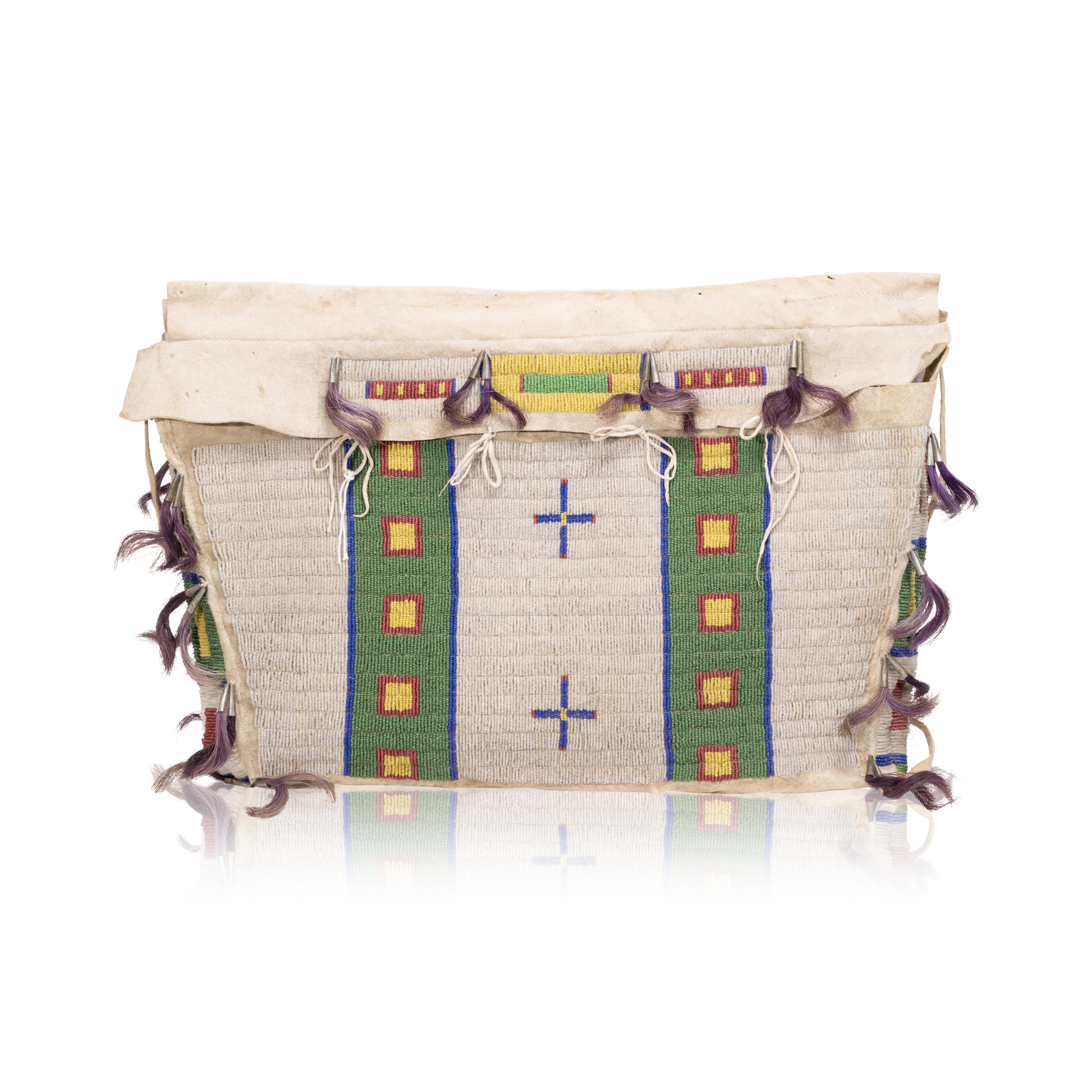 Northern Plains beaded possible bag. Sinew sewn and beaded on softly tanned hide using colors of red white heart, pea green, greasy yellow, royal blue and pearl. Accented with tin cones and purple dyed horsehair. 21