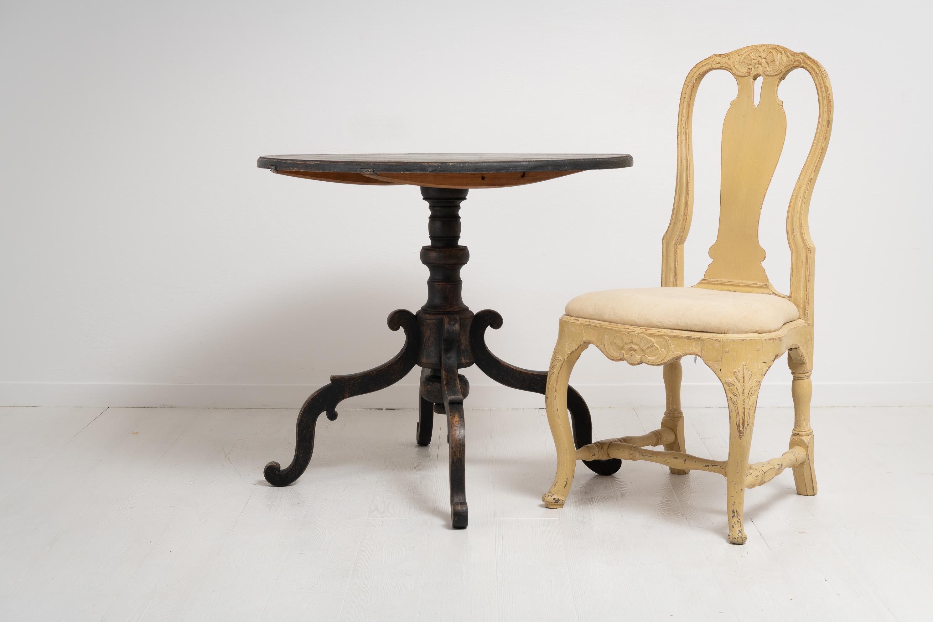 19th century northern Swedish large black tilt-top table with a large center table top and pedestal base with 4 ornate legs. The shape of the legs is unusual with the almost spider shaped legs. Made in Swedish pine with distressed black paint. Dated