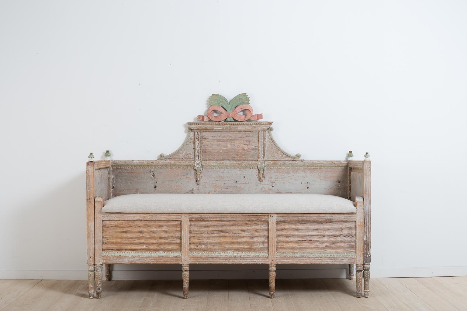 Gustavian sofa or solsäng from Hälsingland. The Swedish name solsäng literally means sun bed. The sofa have rich wooden carvings all around and the surface has been scraped to the original first layer of paint. The seat is newly renovated with new
