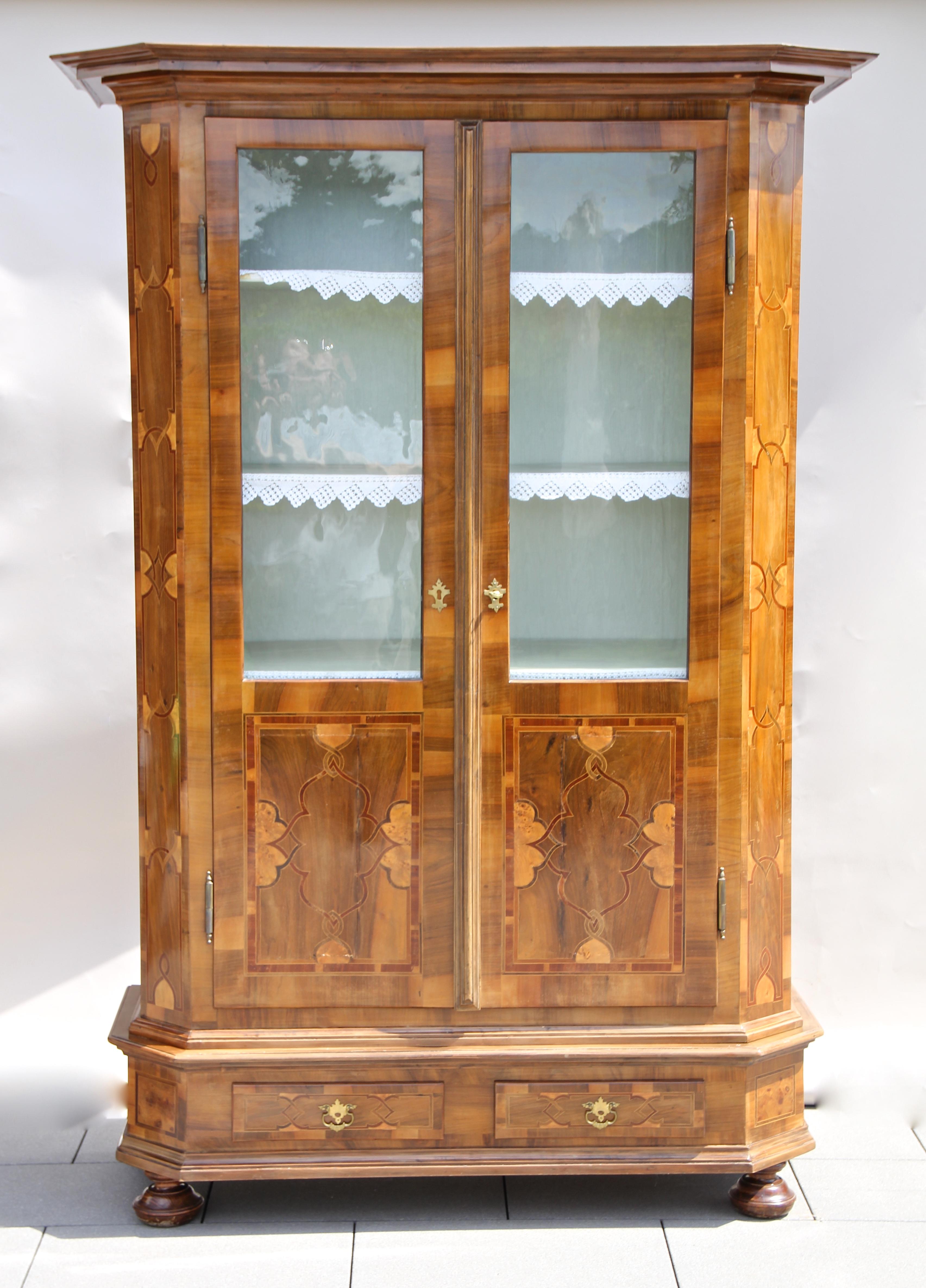 Fantastic 19th century Nutwood bookcase or cupboard with inlay works from the famous Baroque Revival period circa 1890 in Austria. The large elaborately handcrafted cabinet impresses with its outstanding marquetry works and provides two glass