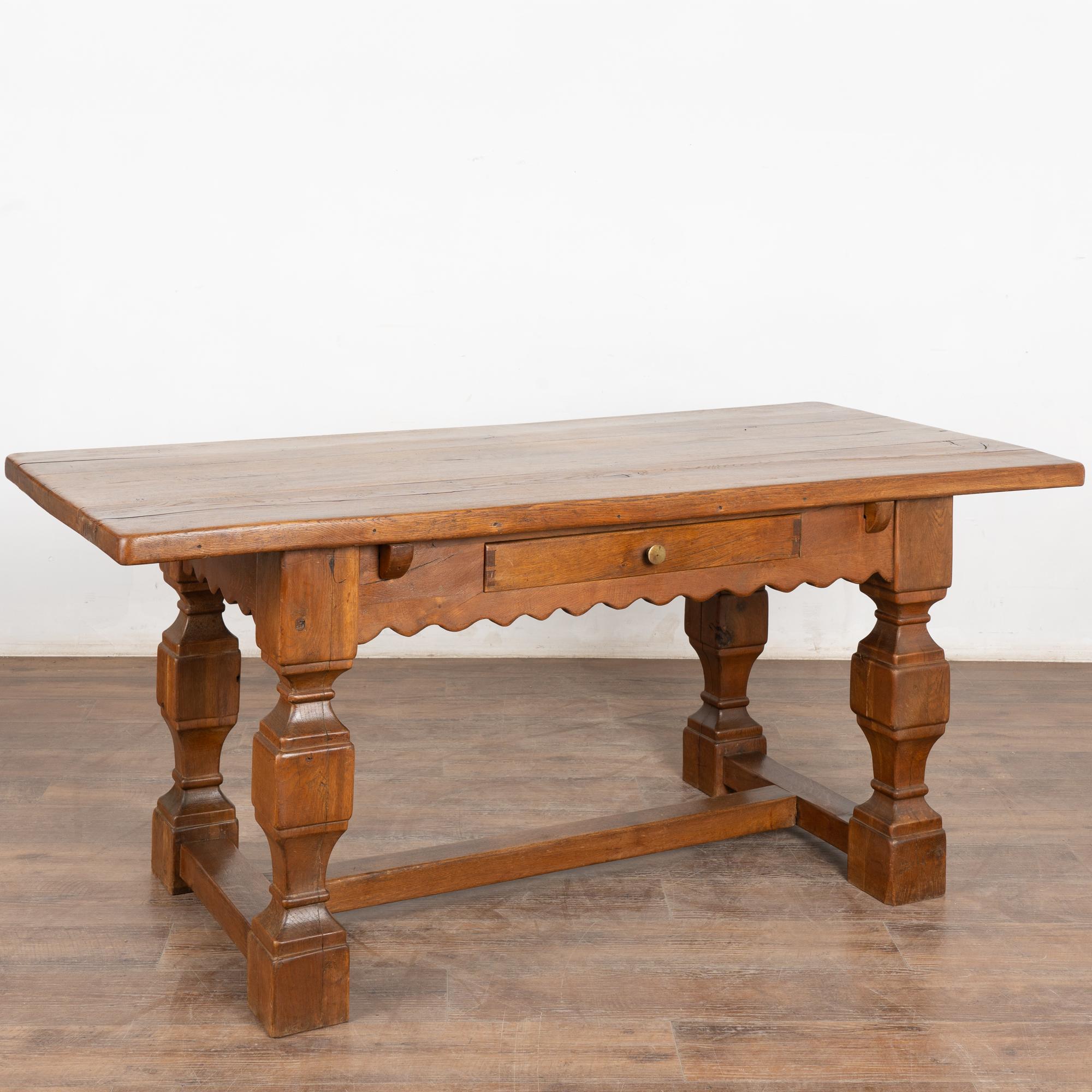 This handsome baroque style oak library table with one drawer has heavily turned legs, scalloped skirt and lower stretcher.
The top is all natural oak with nicks, cracks and stains reflecting generations of use.
Restored, strong, stable and ready