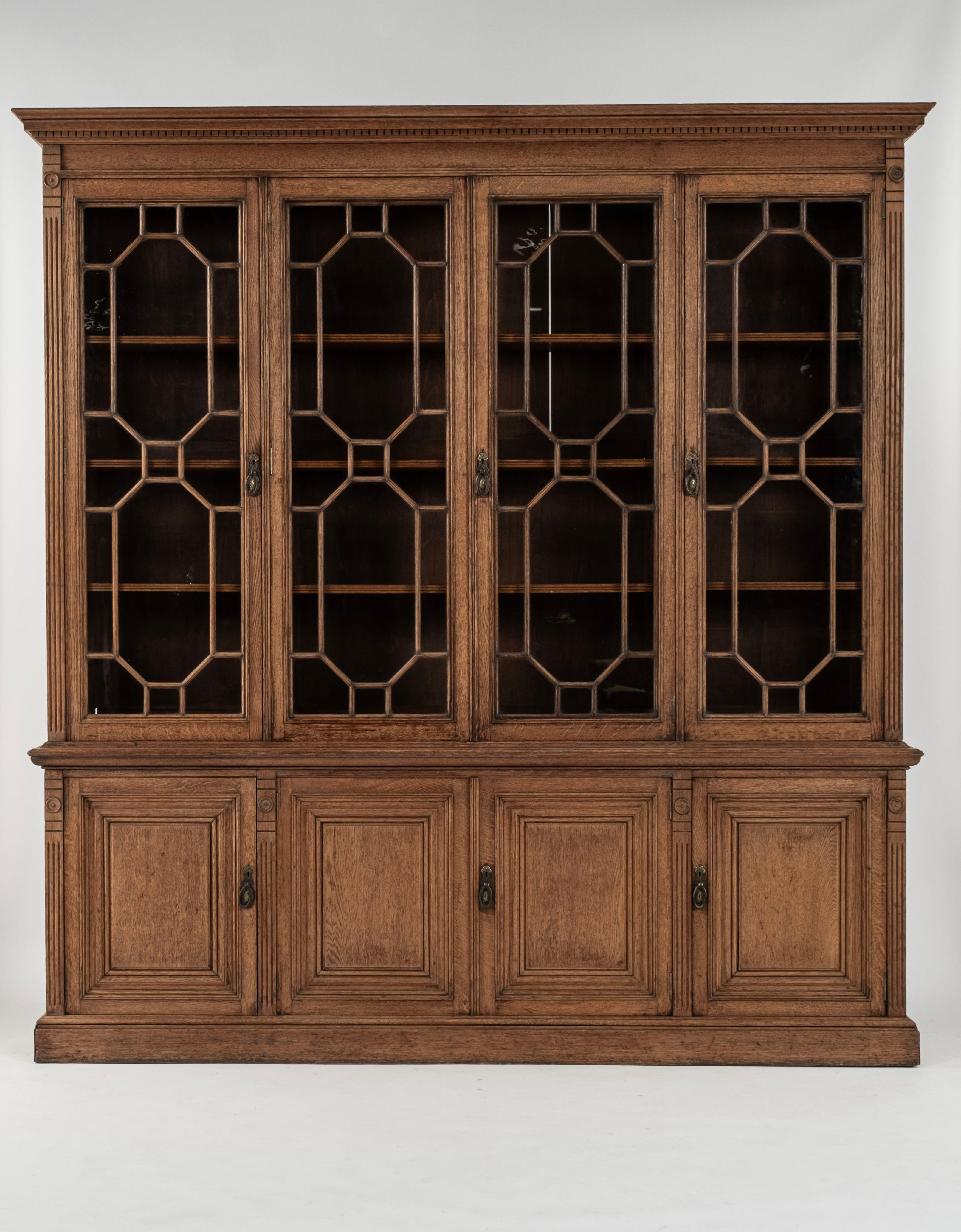 Libreria in Oak inglese del XIX secolo di James Shoolbred  Una favolosa libreria in rovere smaltato astragale inglese del XIX secolo di James Shoolbred. Ha un cornicione modanato a dentello nella parte superiore e quattro sorprendenti pannelli