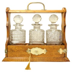 Victorian Oak & Brass Cased Lockable Tantalus With Three Cut Glass Decanters