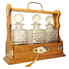 Victorian Oak & Brass Cased Lockable Tantalus With Three Cut Glass Decanters