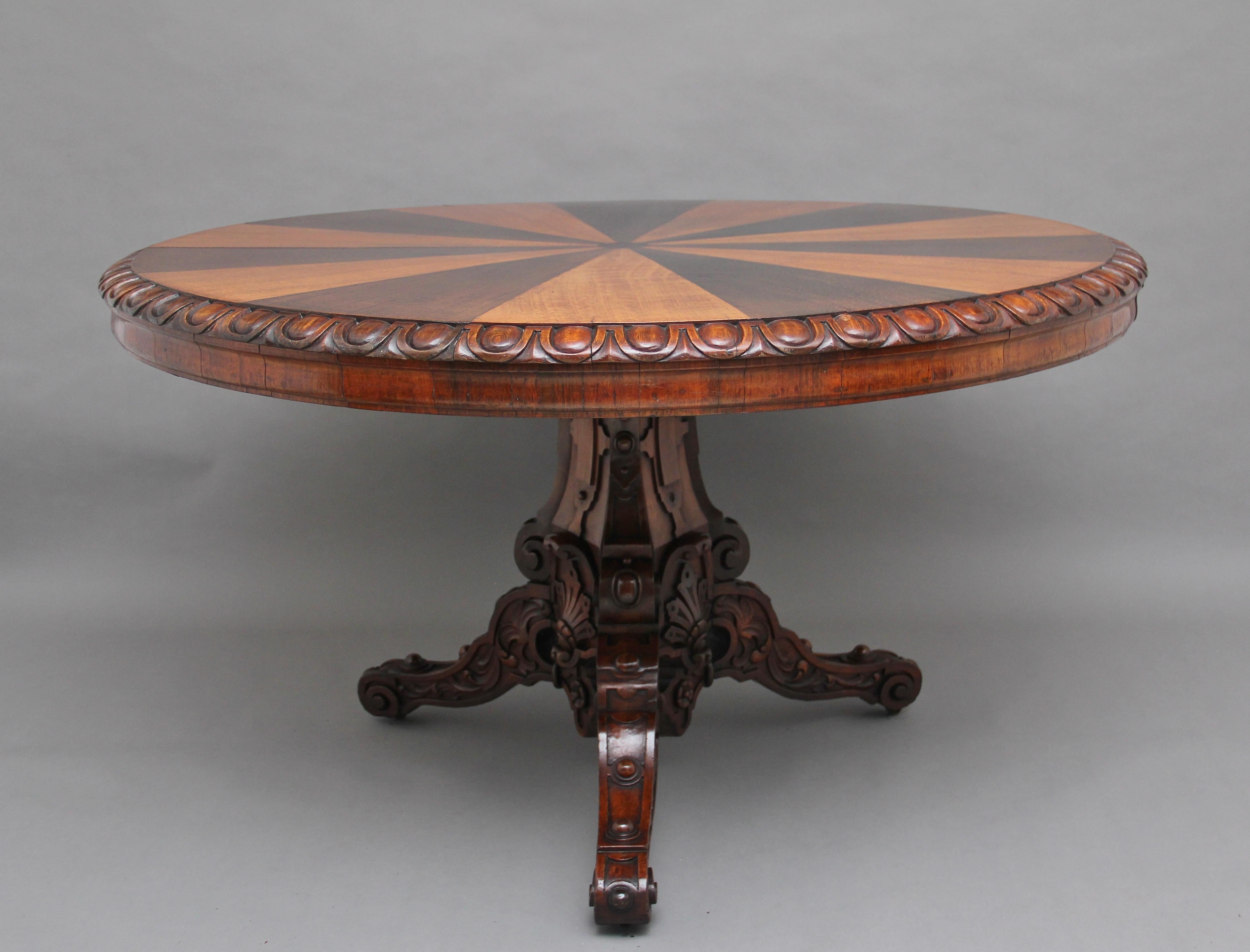 A lovely quality mid-19th Century oak breakfast / centre table having a decorative segmented top with a gadrooned edge supported on a heavily carved tri form column terminating on three shaped and carved legs with scroll feet, circa 1860.