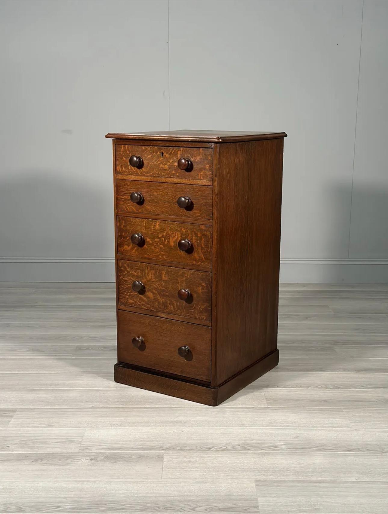 A tallboy chest of drawers dating to the late 19th century, English made with superb quarter sawn oak the chest has 5 staggered in size drawers with original turned oak knobs and is in very good original condition with label to the back showing