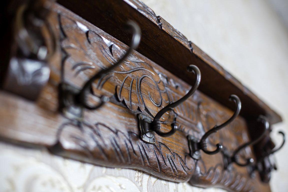 We present you this oak coat rack from the late 19th century.
There are five metal hooks on the rear wall, and the whole is covered with a relief pattern.

The item is in very good condition.