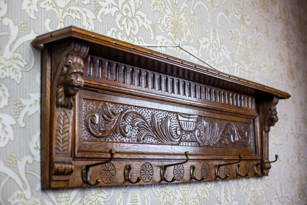 We present you an oak coat rack with seven hooks and a shelf.
The rear wall is decorated with a floral motif.

This item has not undergone renovation but is in very good condition.