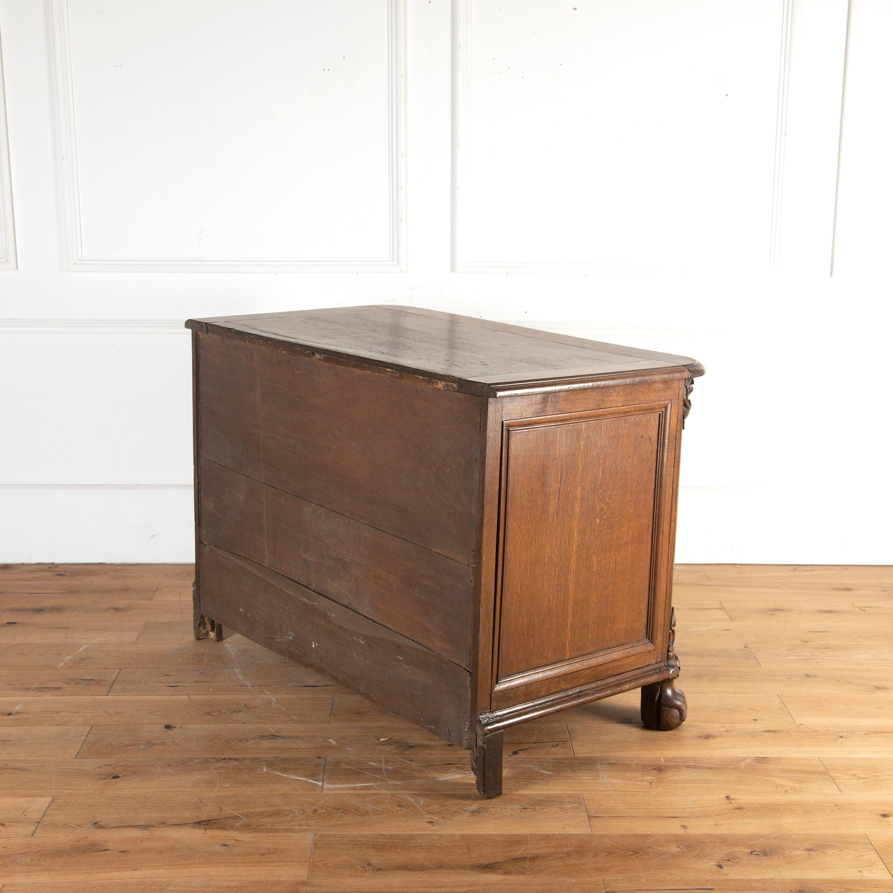 Pretty 19th century oak commode.

This substantial yet elegant commode has panelled sides and offers three drawers, with decorative brass handles and escutcheons. 

Resting on deeply carved lion's paw feet. 

This commode has lovely