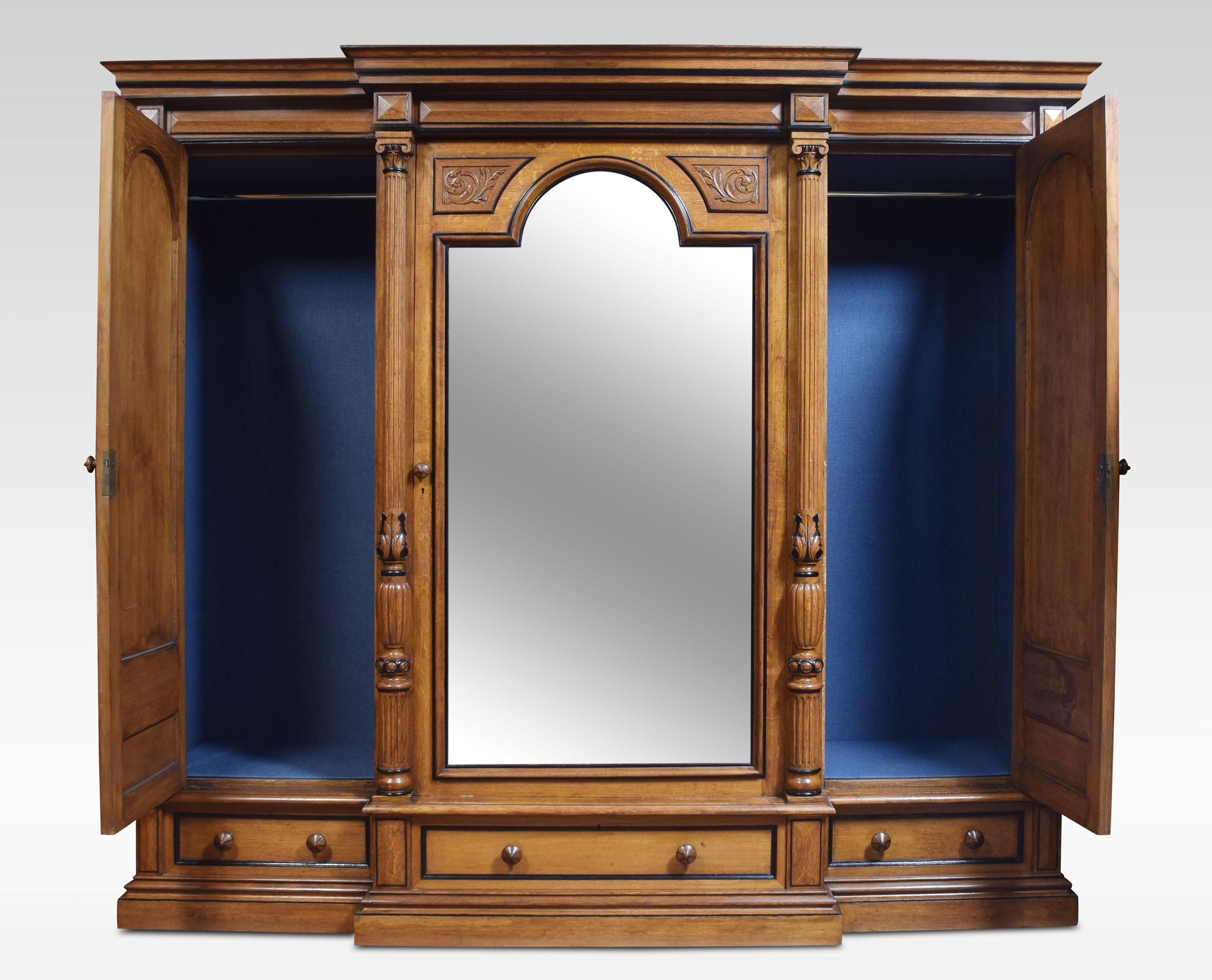 Very large late 19th century oak and ebonized compactum wardrobe, of breakfront outline. The moulded cornice above a large central mirrored door enclosing a fully fitted interior comprising of hanging area ideal for trousers and three large