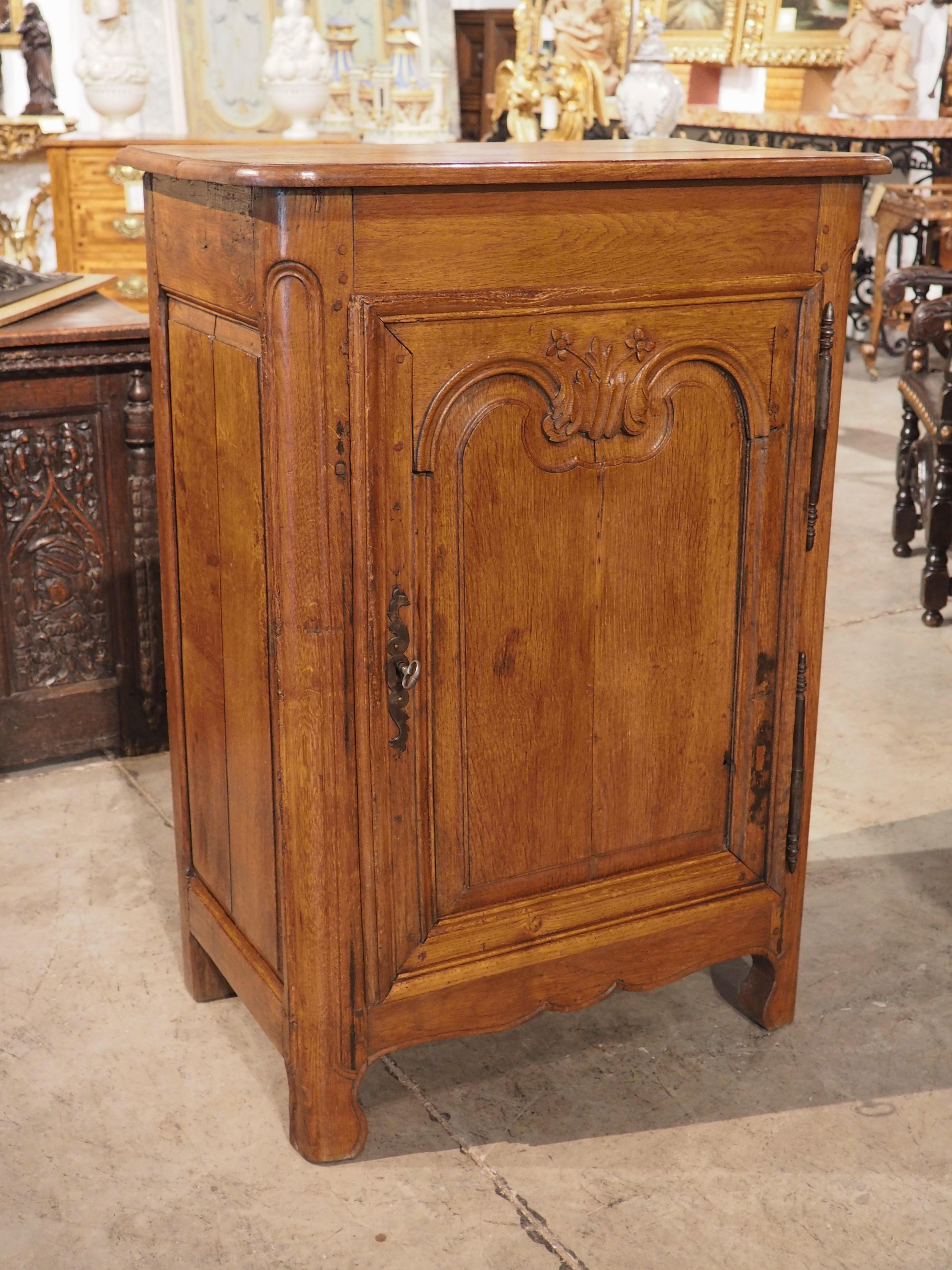 This 19th-century oak confiturier cabinet from Normandy, is an excellent display of the  fine craftsmanship of regional French woodworkers of the 1800s. The thick molding to the door, with its intricate floral bush at the top, adds a touch of