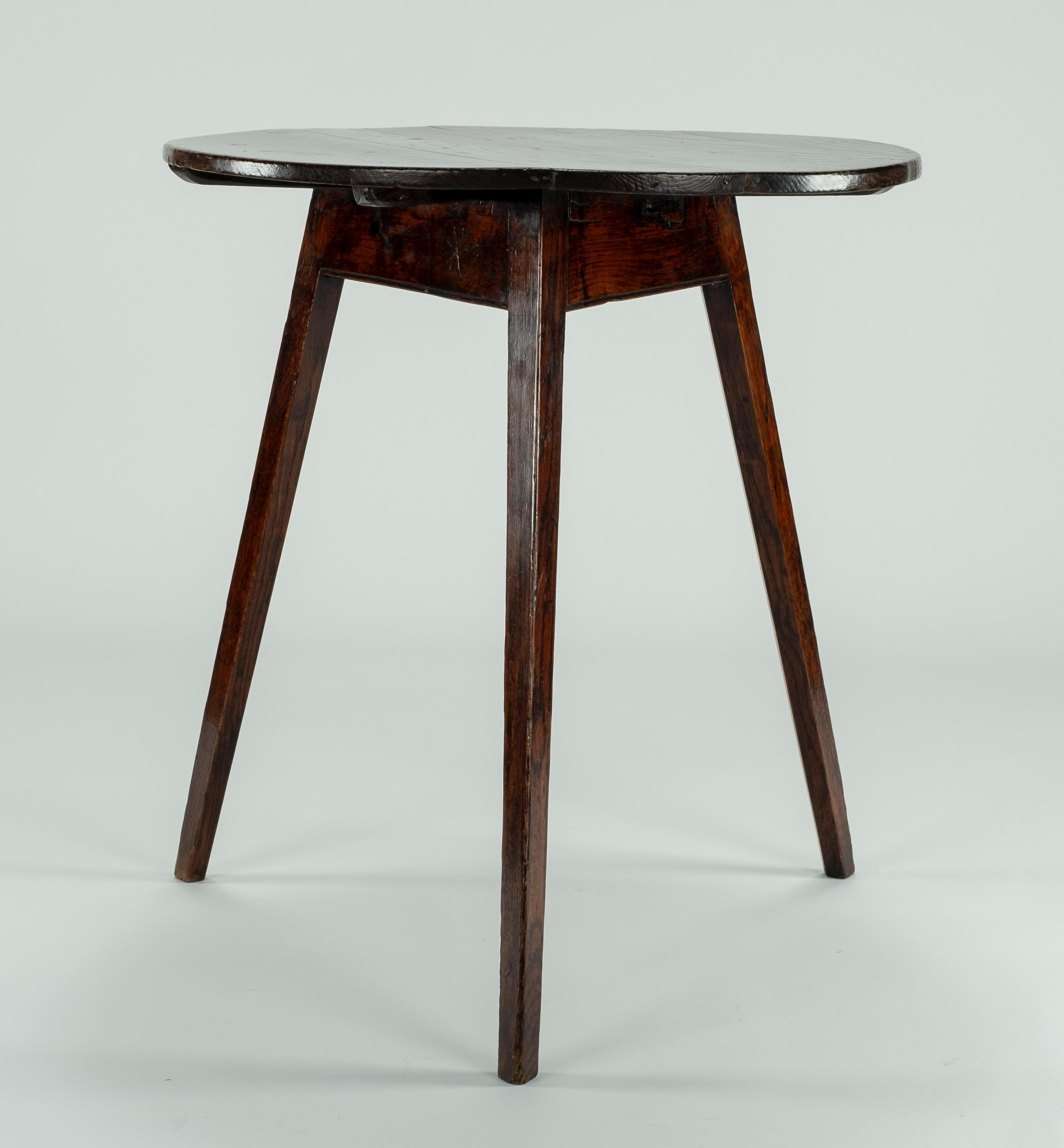 19th century oak cricket table with a flat apron on 3 slightly splayed legs.