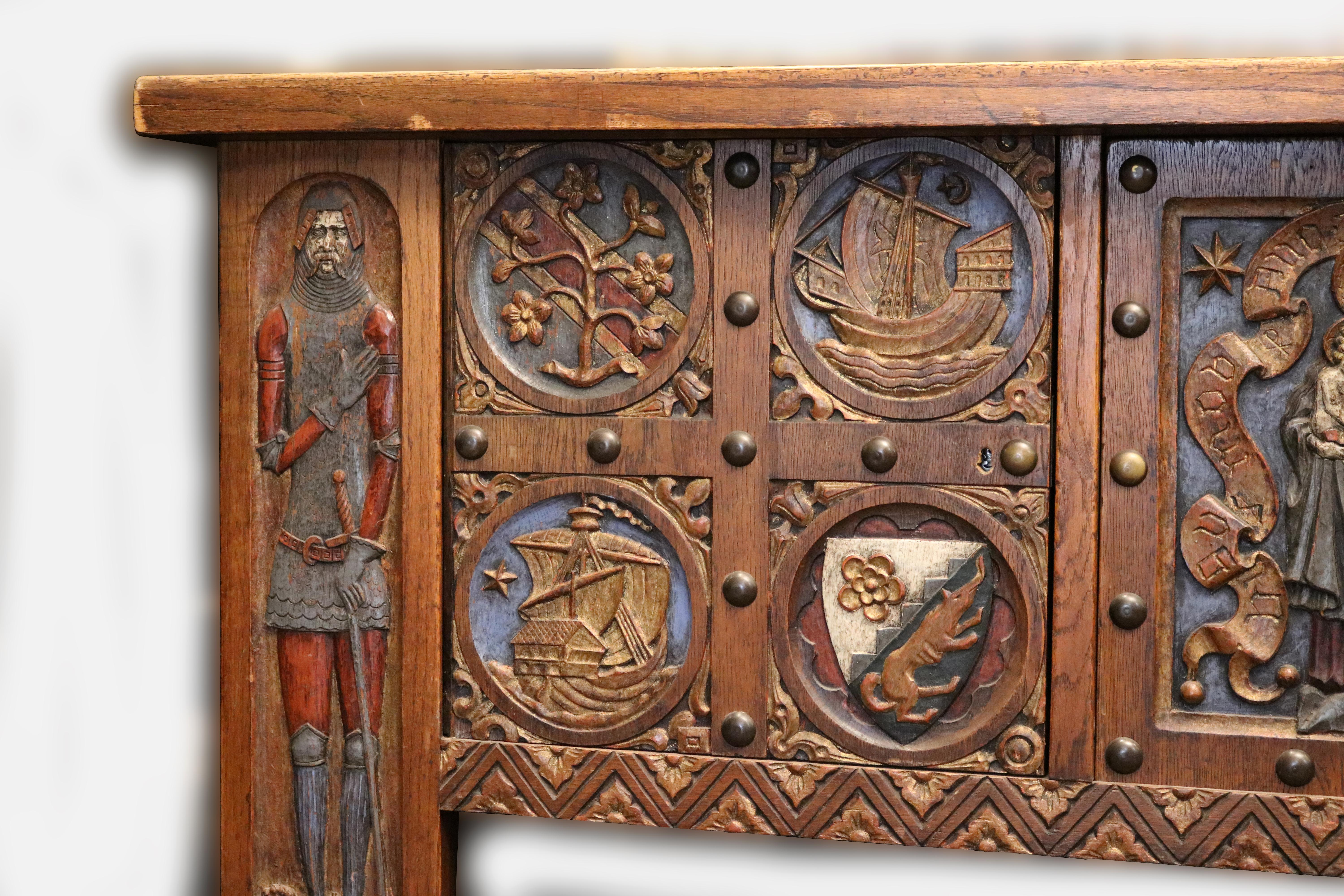 with superbly carved frontage depicting a knight on the left capital and a finely carved lady on the opposite side. The central cupboard door depicting Christ as a child held in the arms of the Virgin Mary. The central cupboard flanked at each side,