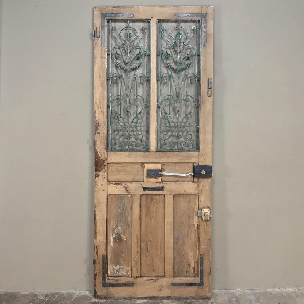 19th century Art Nouveau oak entry door with wrought iron makes an excellent choice for an impressive entryway or passage. Bold molded detail combines with the artistically forged wrought iron for a classic touch. Many admirers consider the Art