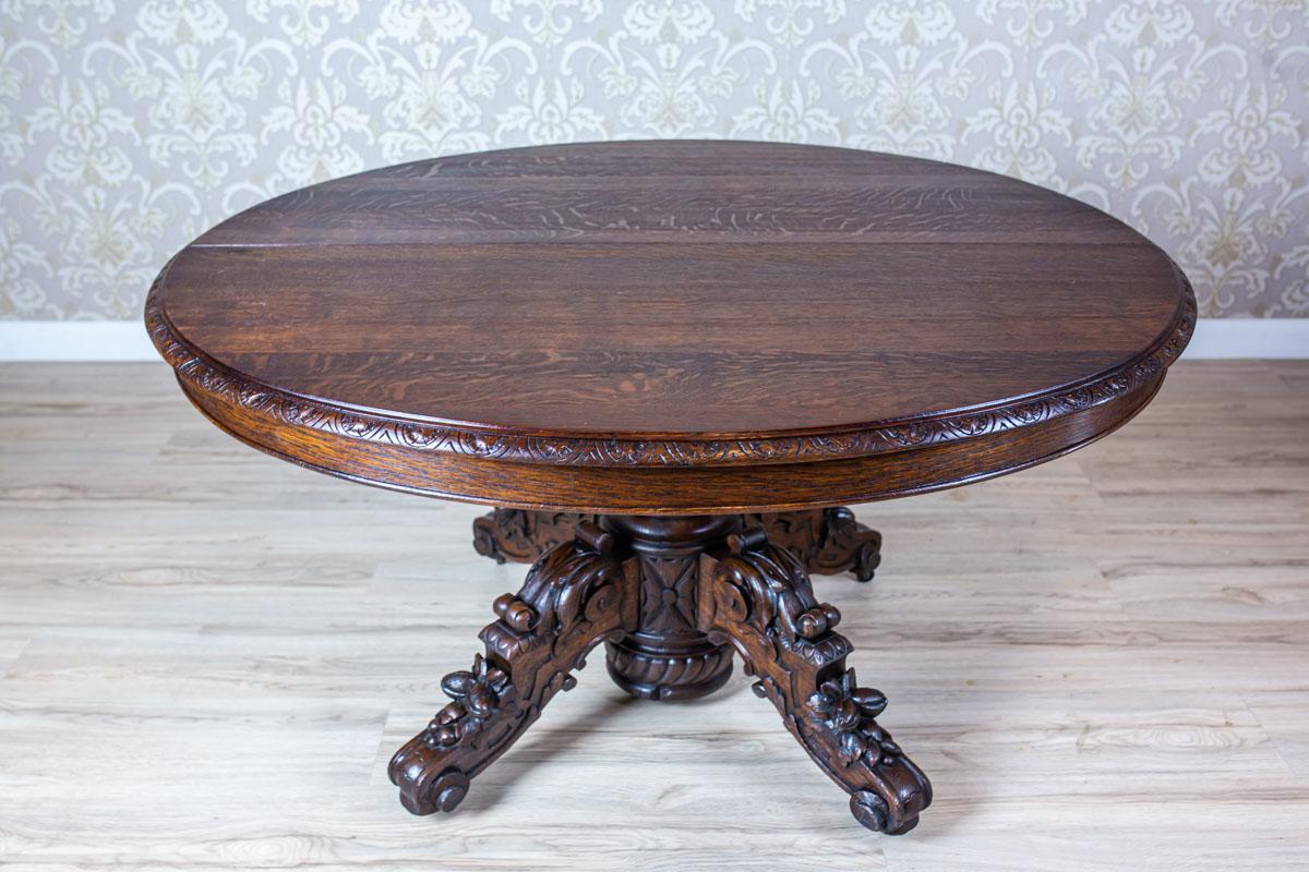 We present you a solid piece of furniture with an oval extendable top, which is supported on a rounded pedestal on four volute legs.
All is from the late 19th century.
In the apron section, there are hidden additional legs to support the extended