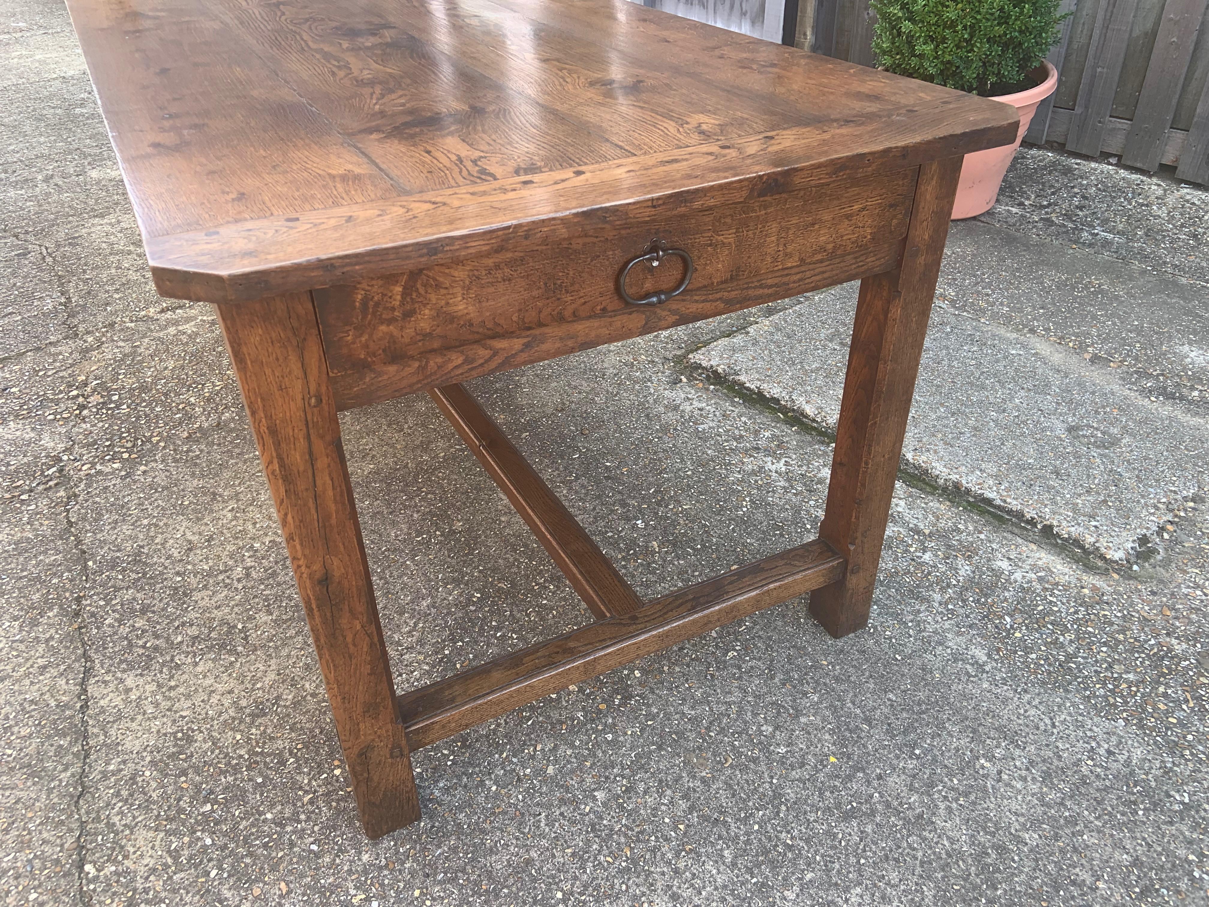 19th Century Oak Farmhouse table with side drawer. The table sits on an h and centre stretcher base. The top of the table has cleated clipped corners. Beautiful colour and patination.
 