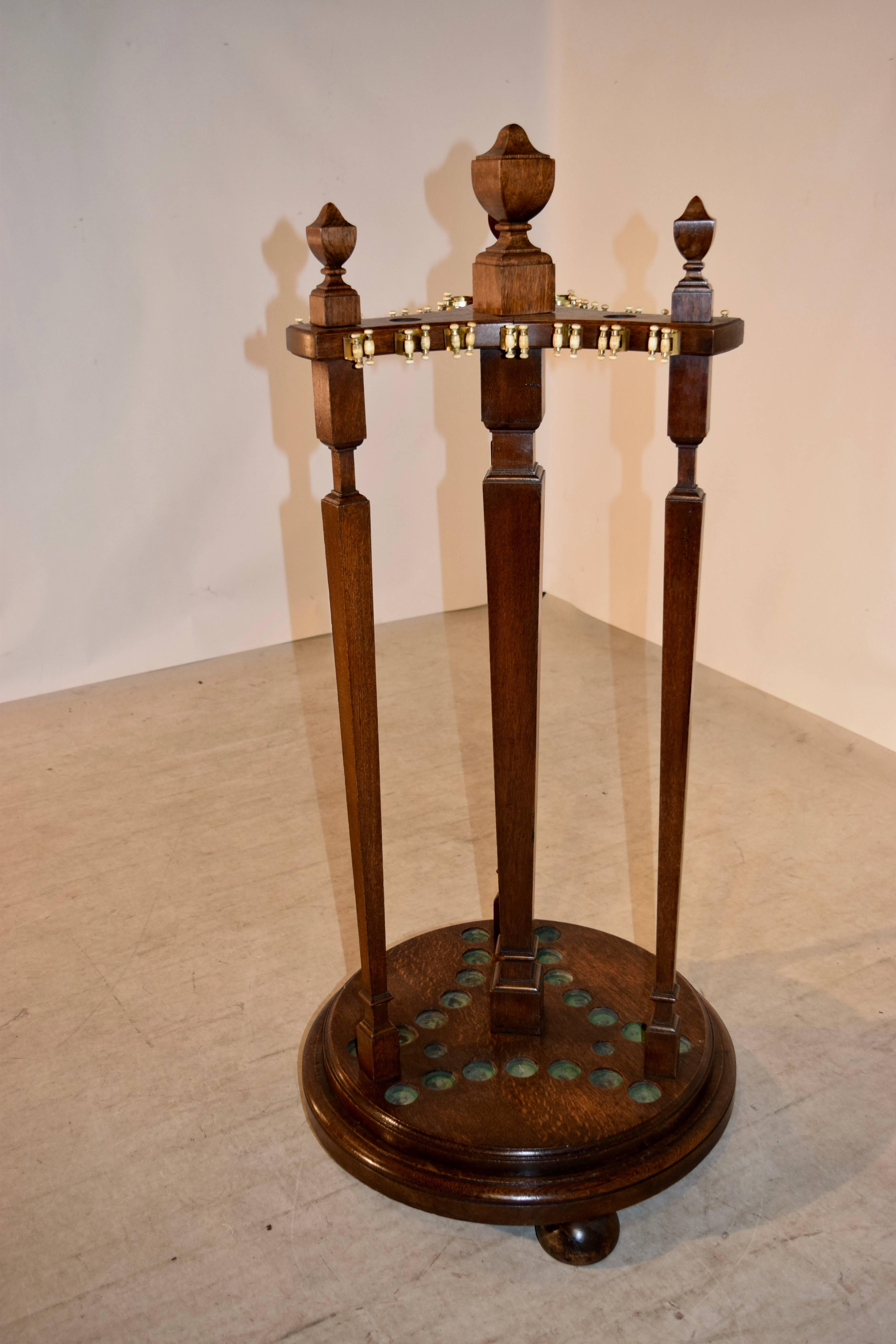 Late 19th century solid oak billiard, snooker, or pool cue stand of nice size and quality. It is a carousel design standing on a molded revolving turntable base, supported on hand turned bun feet. The stand is supported by a central hand turned