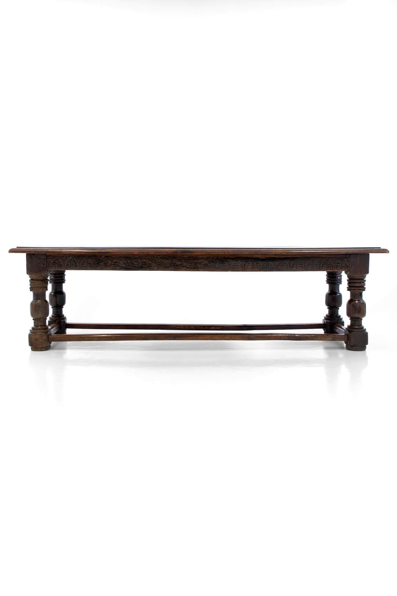 Early 19th century English Oak refectory table with moulded edge and earlier 18th century elements to the table base. Heavy triple plank top over decorative hand-carved stiff leaf frieze and four turned balusters legs united by a box stretcher.
The
