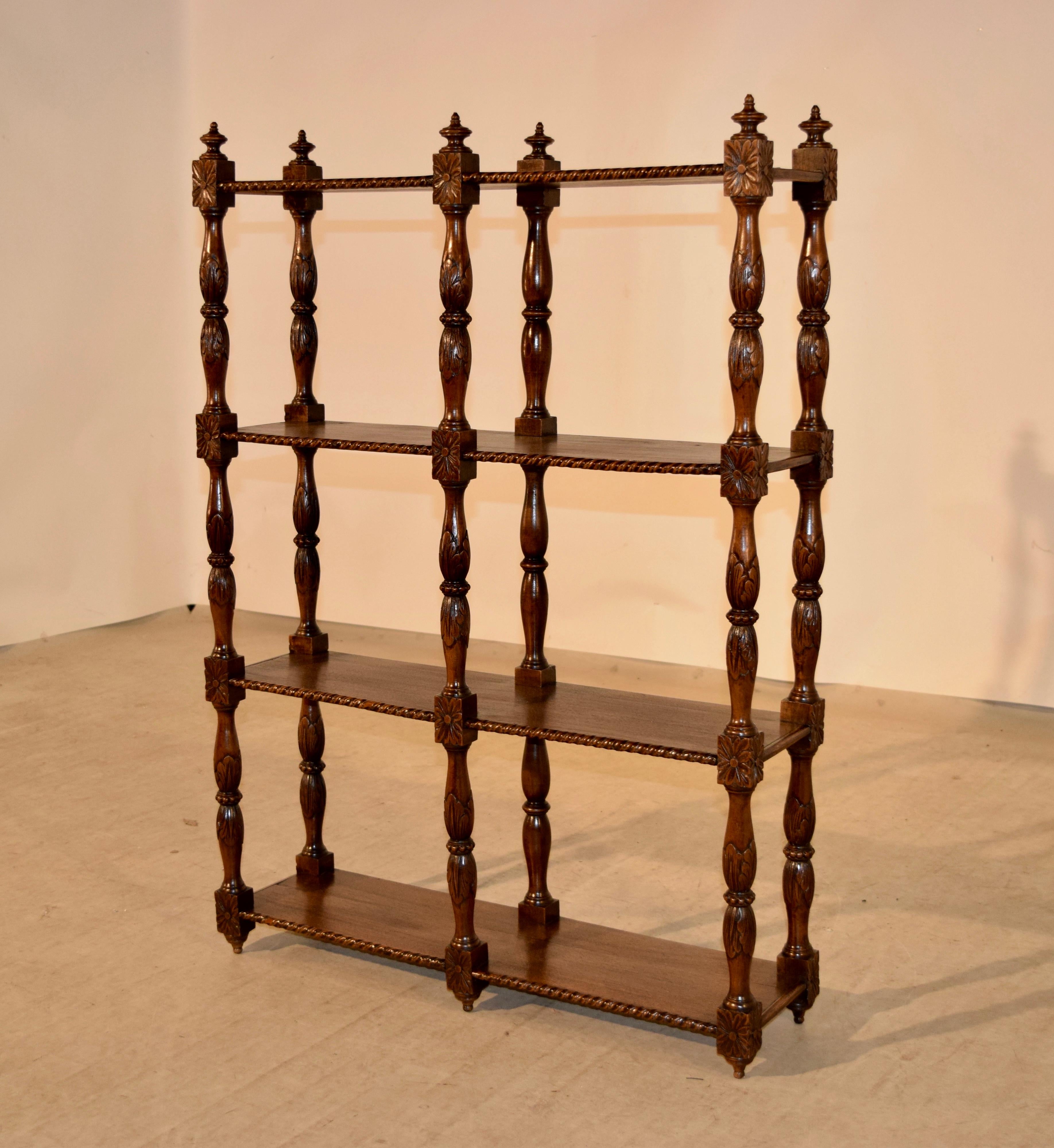 19th century oak shelf from France. The top is decorated with finials, following down to four shelves, which have carved front edges and hand turned and carved decorated shelf supports.