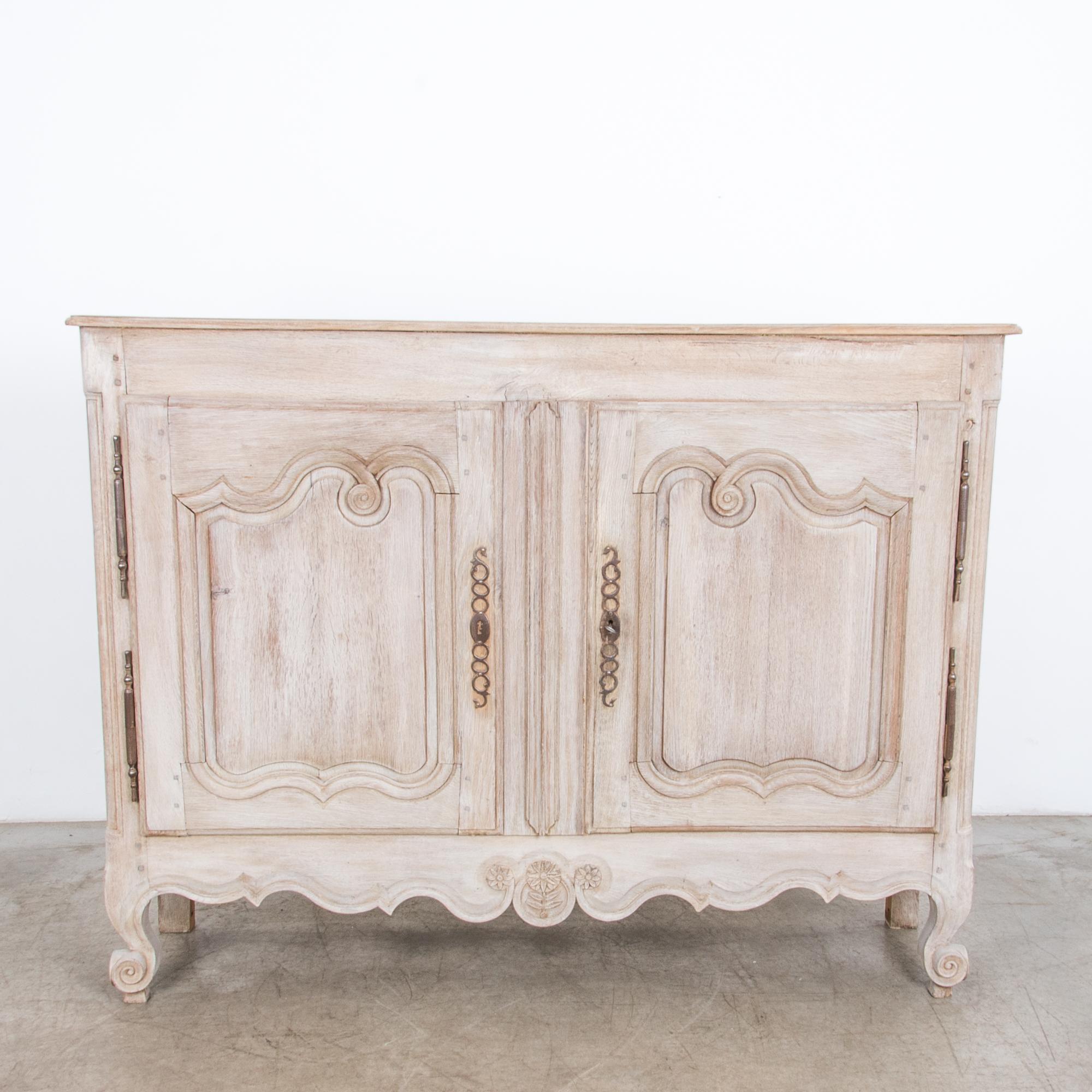 A two-door cabinet from France, circa 1860. Representing the casual yet refined aesthetic of the French countryside, in a contemporary bright finish, enhancing the natural textured figure of the wood and subtle carved ornament. A testament to the