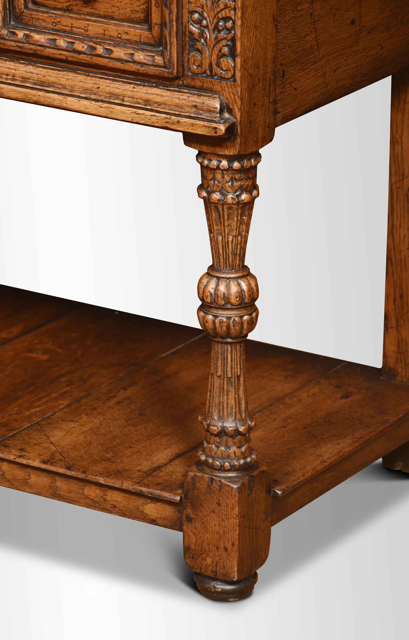 table d'appoint en chêne du XIXe siècle, le grand plateau rectangulaire surmontant une paire de tiroirs à panneaux sculptés entrecoupés de panneaux à feuilles d'acanthe sculptées. Le tout est élevé sur des supports sculptés et des blocs unis par un