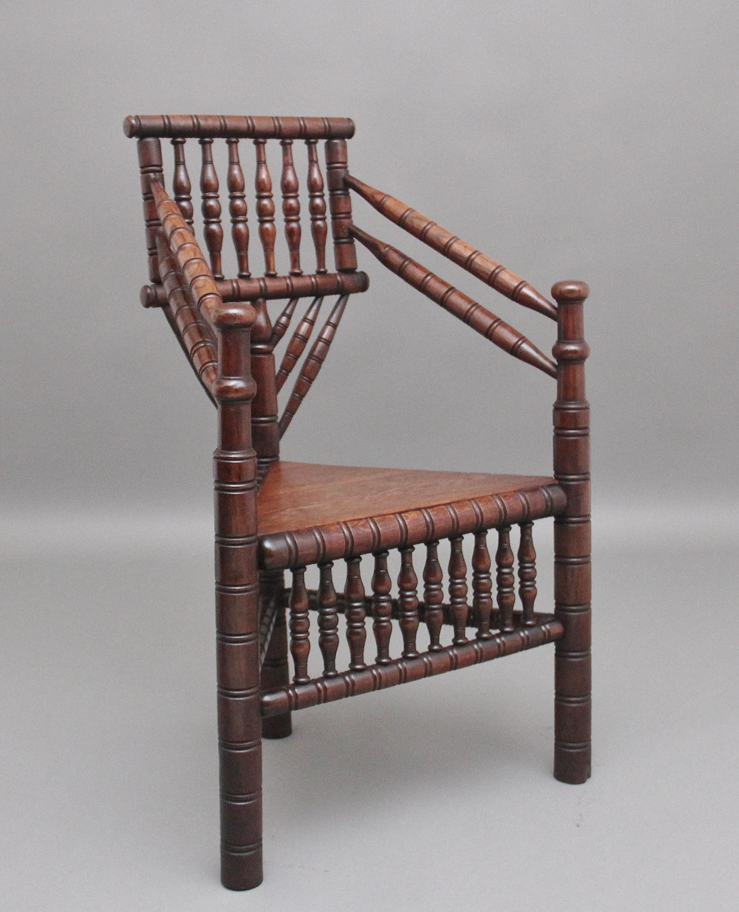 Chaise en chêne du 19e siècle de belle qualité et très décorative, à haut dossier avec accoudoirs tournés en angle, reposant sur trois pieds tournés réunis par des brancards tournés, assise triangulaire en bois, divers fuseaux décoratifs sur