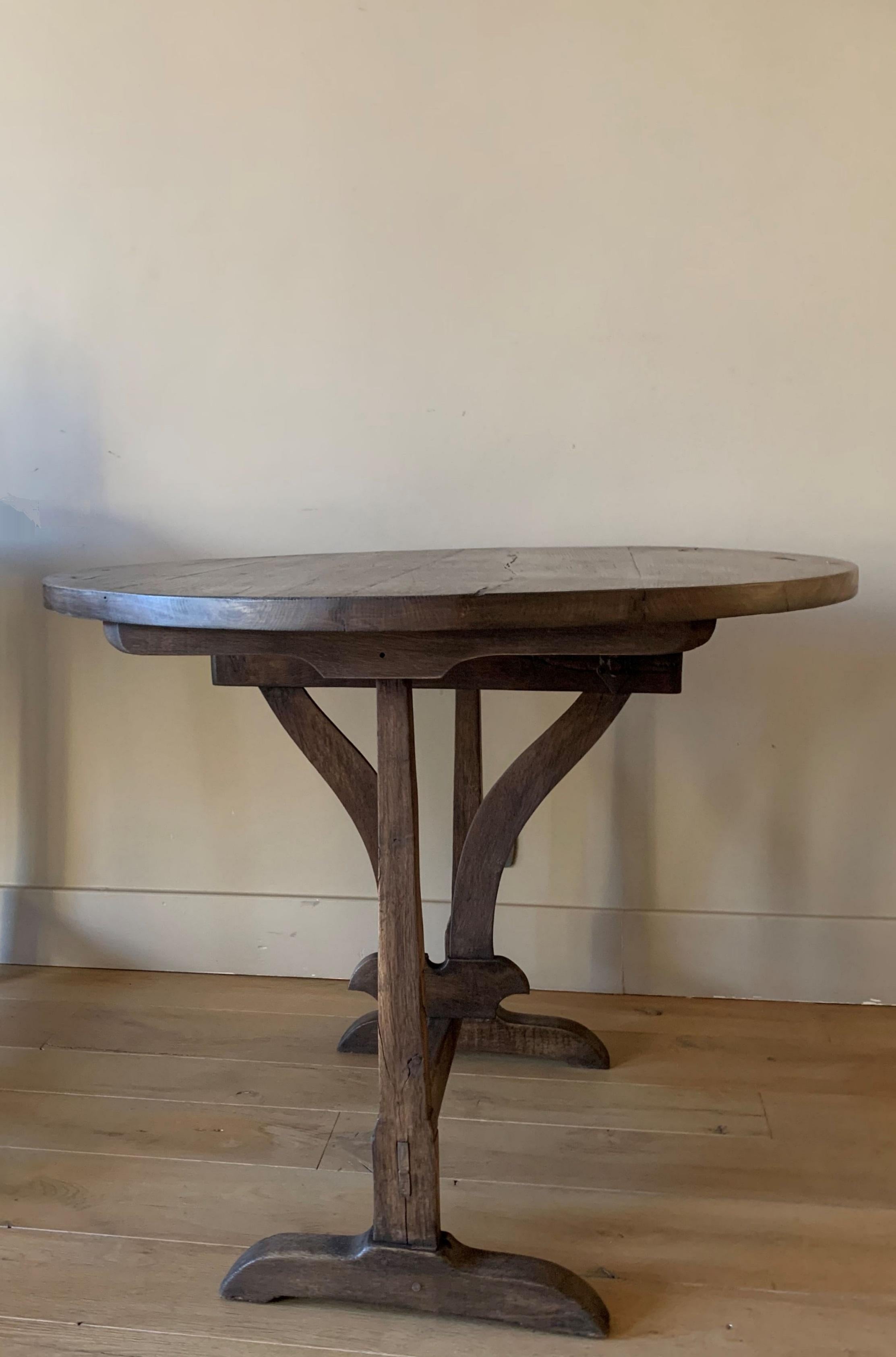 A good 19th century French Winetable. The oak top folds on the oak base.
These Vigneron tables were and are used on the French countryside as occasional tables in winecellars and on the field. Often made by farmers in the wintertime they are