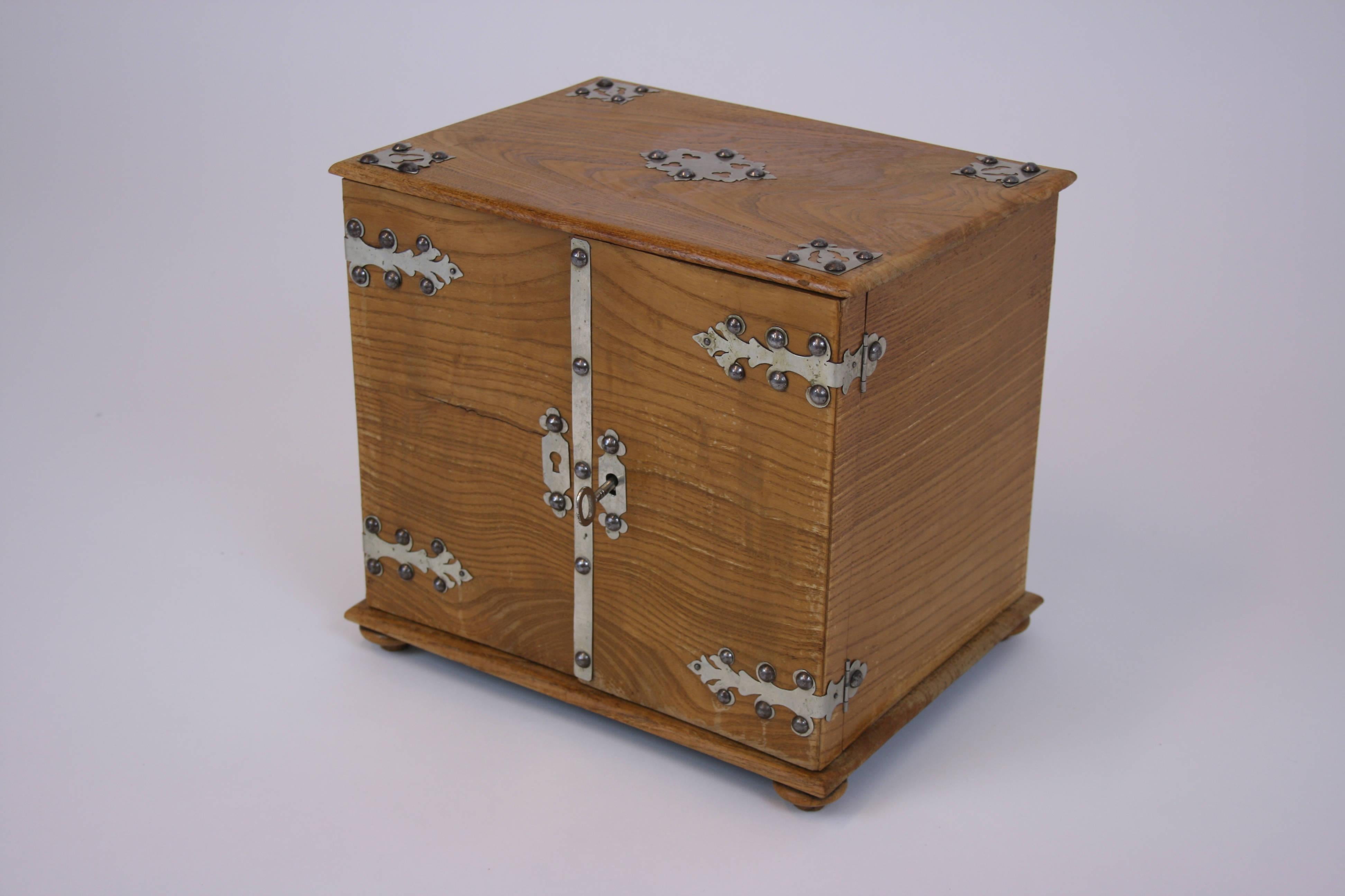 An attractive small oakwood casket most probably manufactured in the late 19th century. This object, richly decorated with external metal fittings has three drawers inside and quotes the style canon of the Italian Renaissance. It is slightly