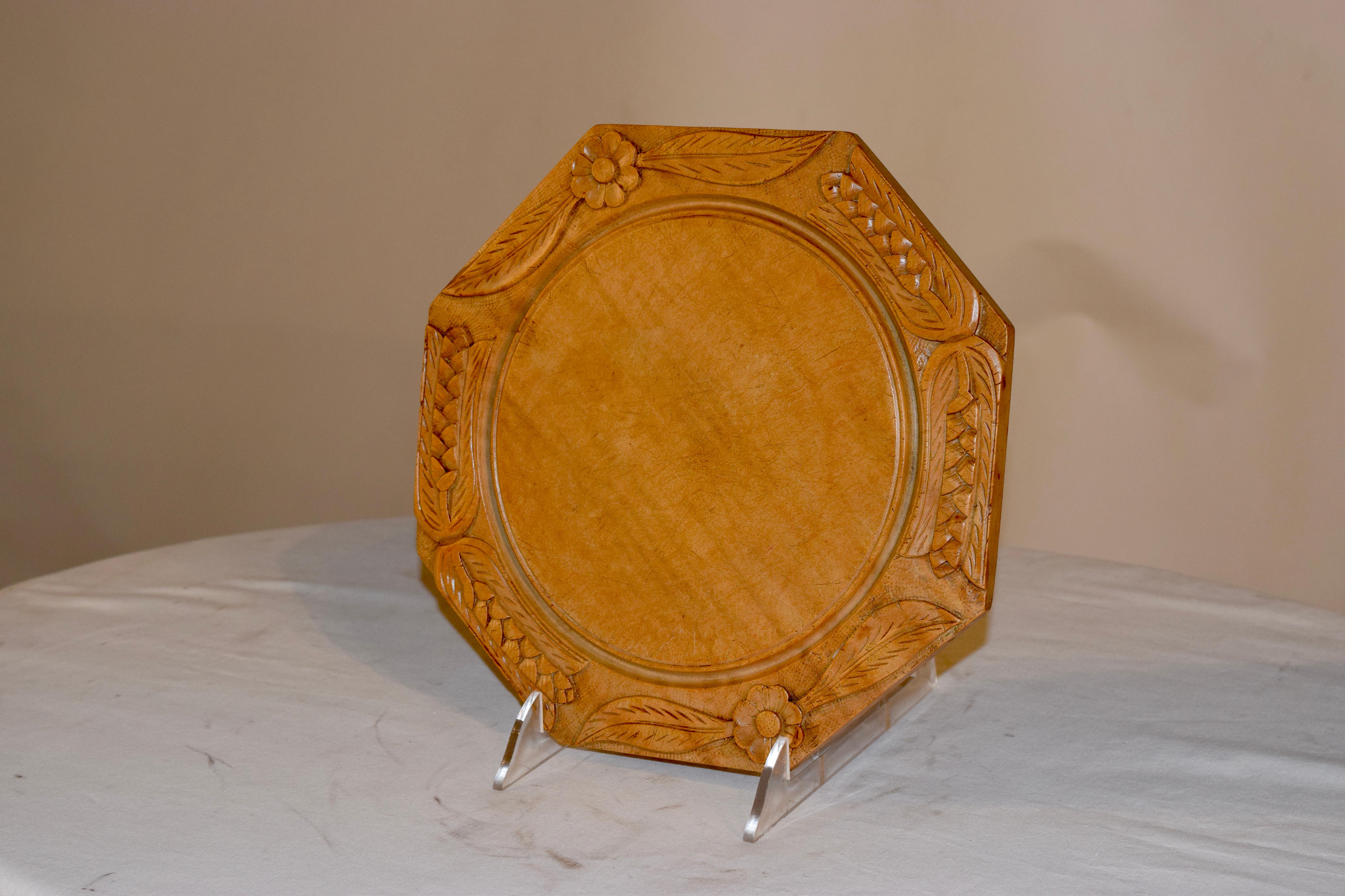 19th century octagonal shaped bread board from England. The border is wonderfully hand carved with decorations of florals and wheat, with a raised center for cutting.