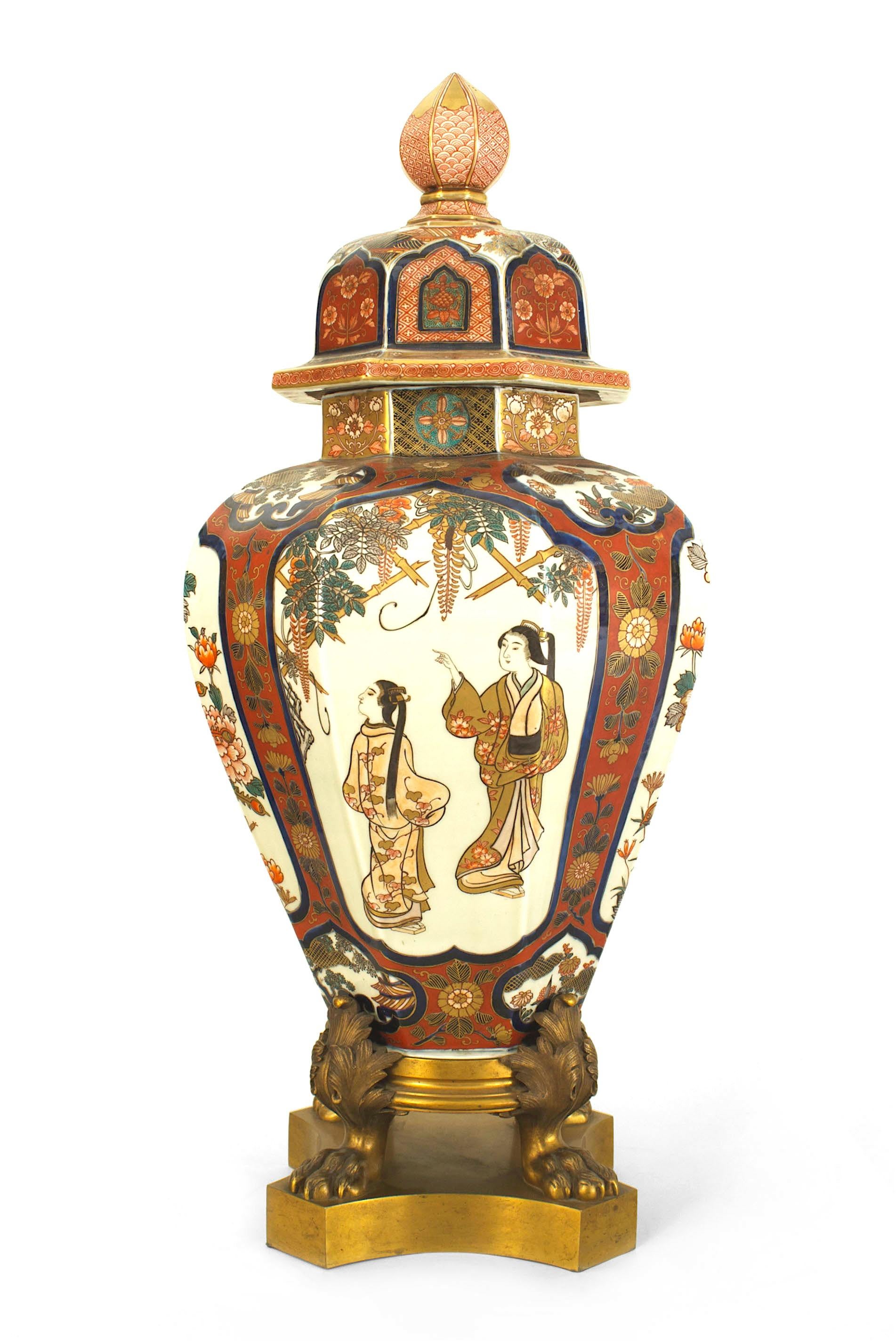 Large octagonal Imari porcelain vase with finial cover and 4 bronze doré claw feet on base (19th century).