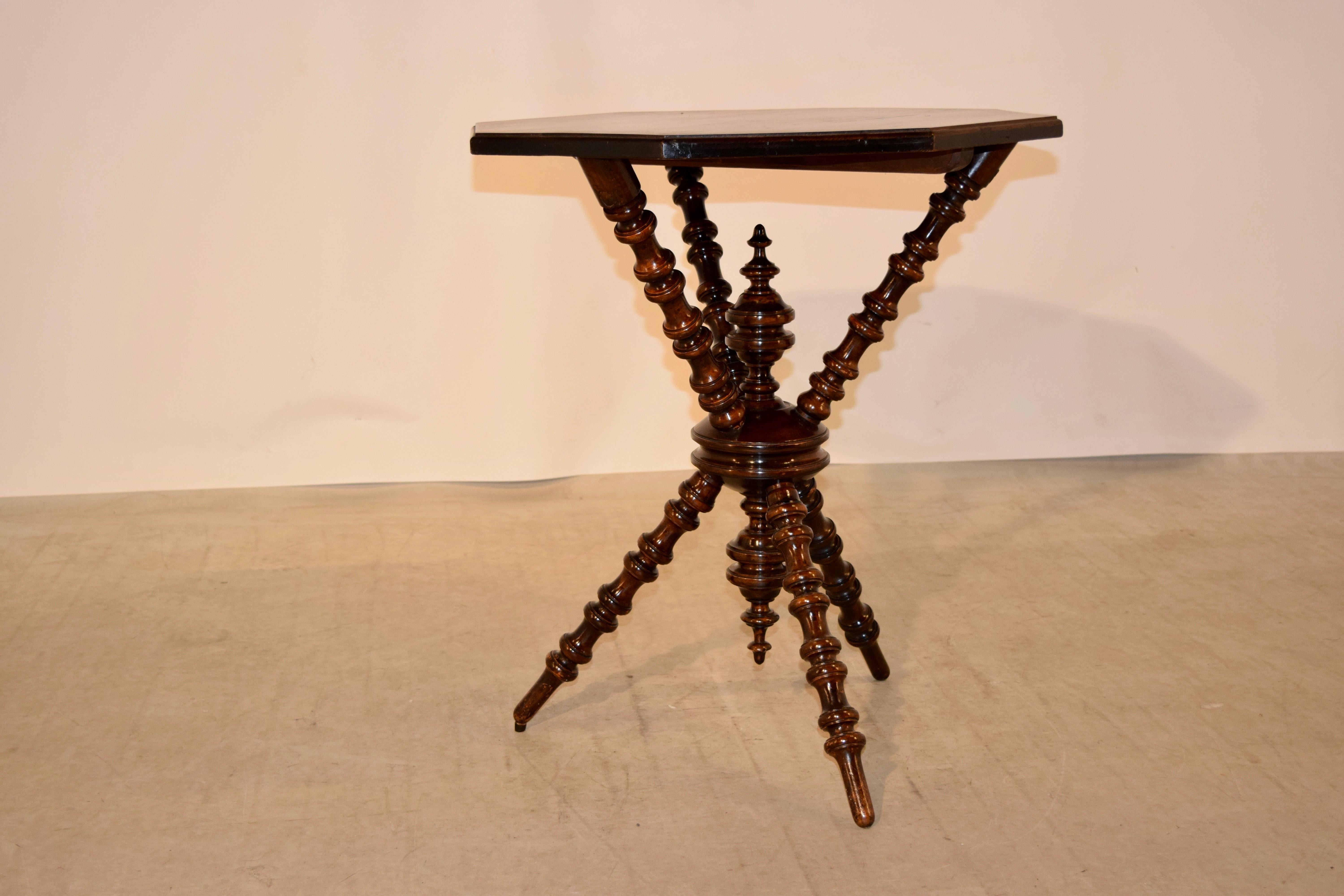 19th century occasional table from France. The top is made of pine and is octagonal in shape, supported on a hand turned base in mahogany with three exquisitely turned legs, joined by a central turned disc and continuing to three hand turned legs,