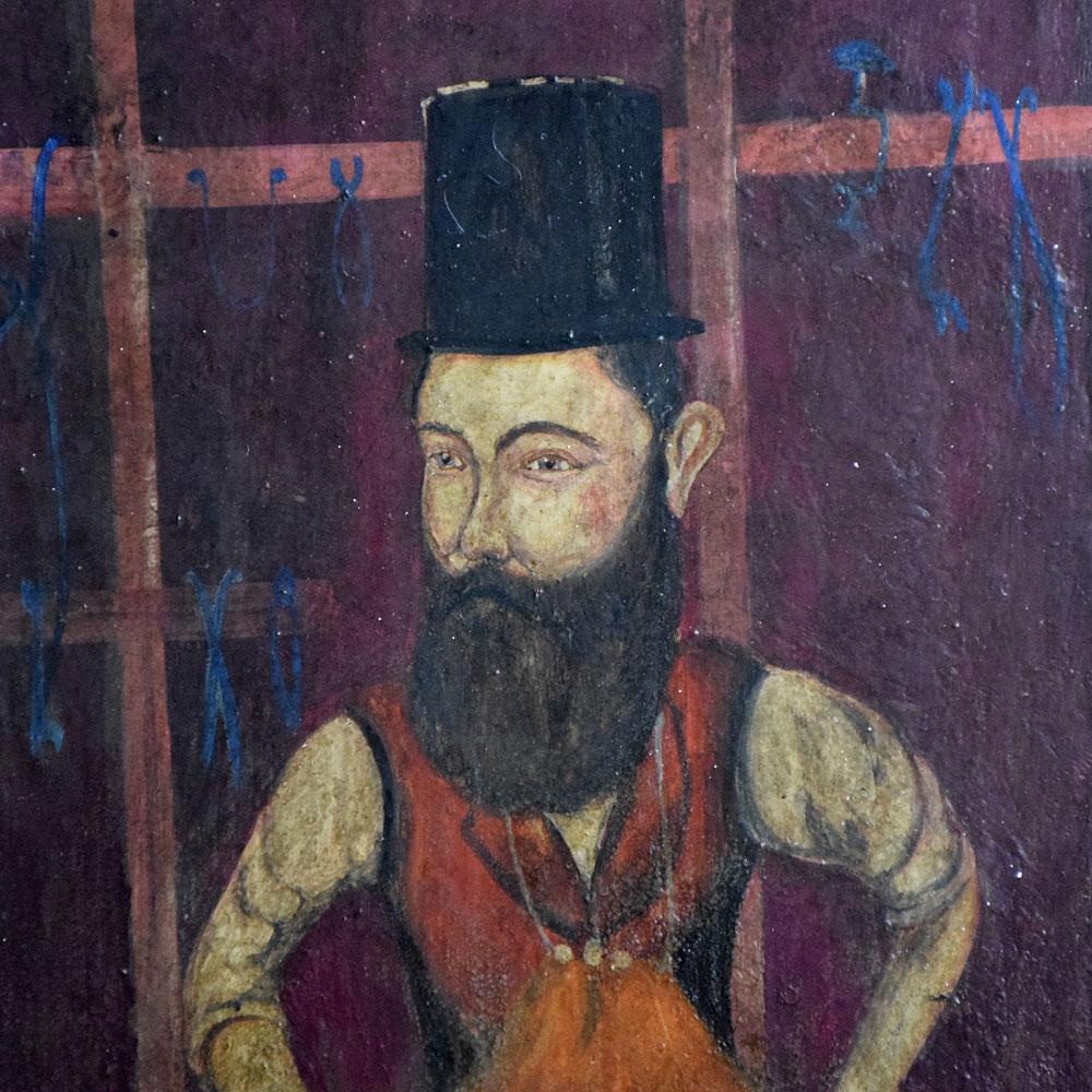 19th century oil on board of a blacksmith.
We are proud to offer a mid-19th century oil on wooden board painting of a blacksmith at work. Painted in the Russian style of naïve folk art, this example shows a sinister looking blacksmith with top hat