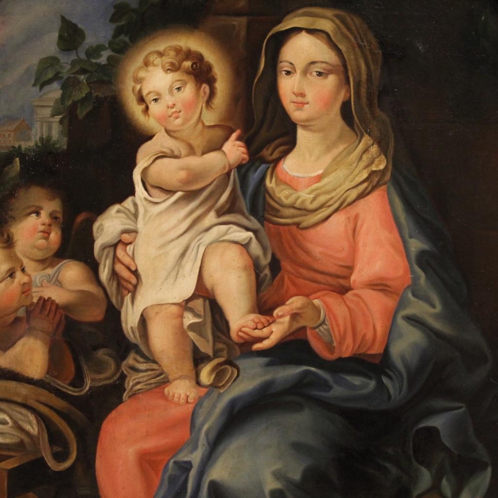 Antique Italian painting from the first half of the 19th century. Work oil on canvas of great brightness and pleasantness depicting a religious subject Madonna with child and little angels of good pictorial quality. Twentieth century frame in carved